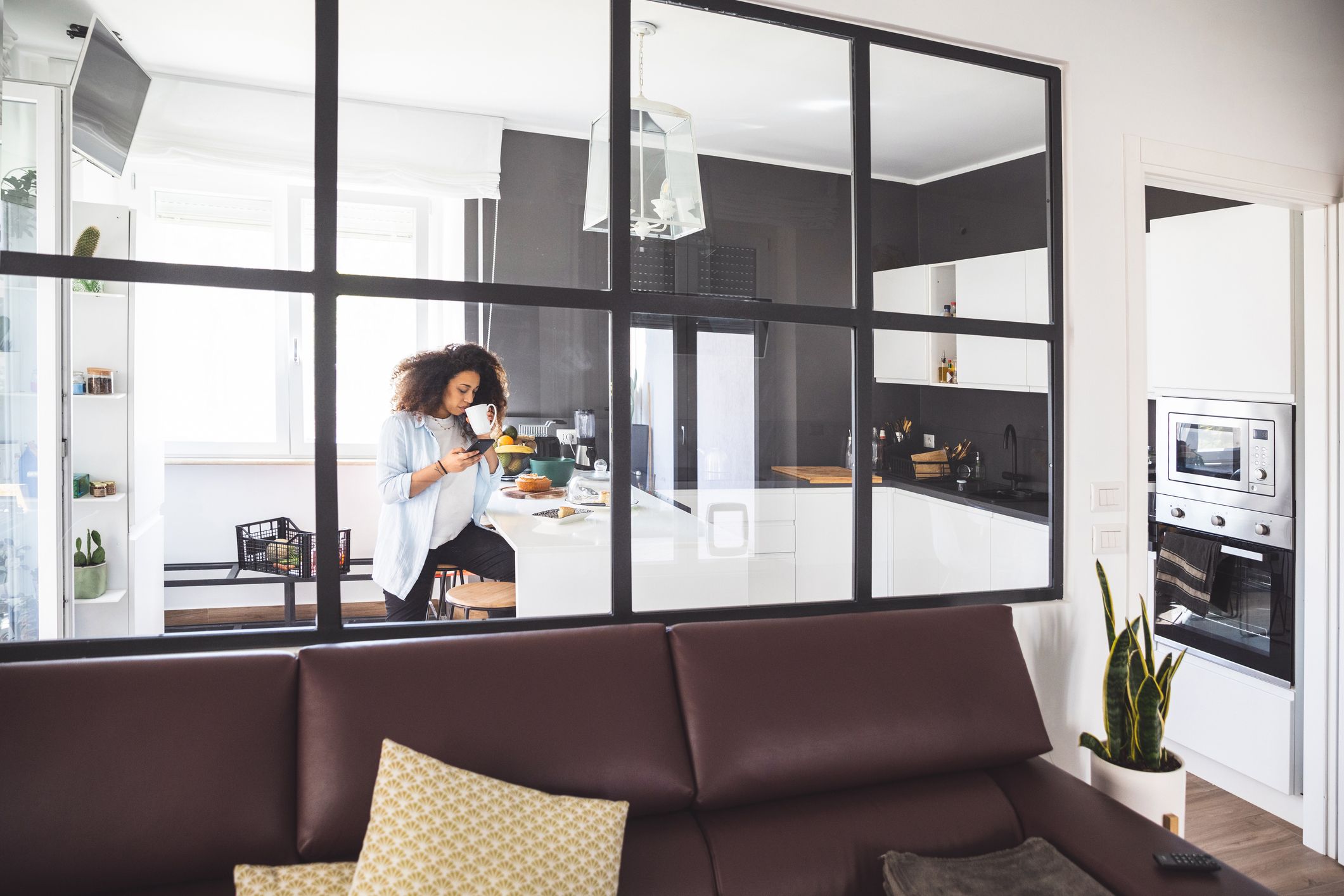 anel de cristal con perfilería negra como alternativa a puertas para separar cocina y salón