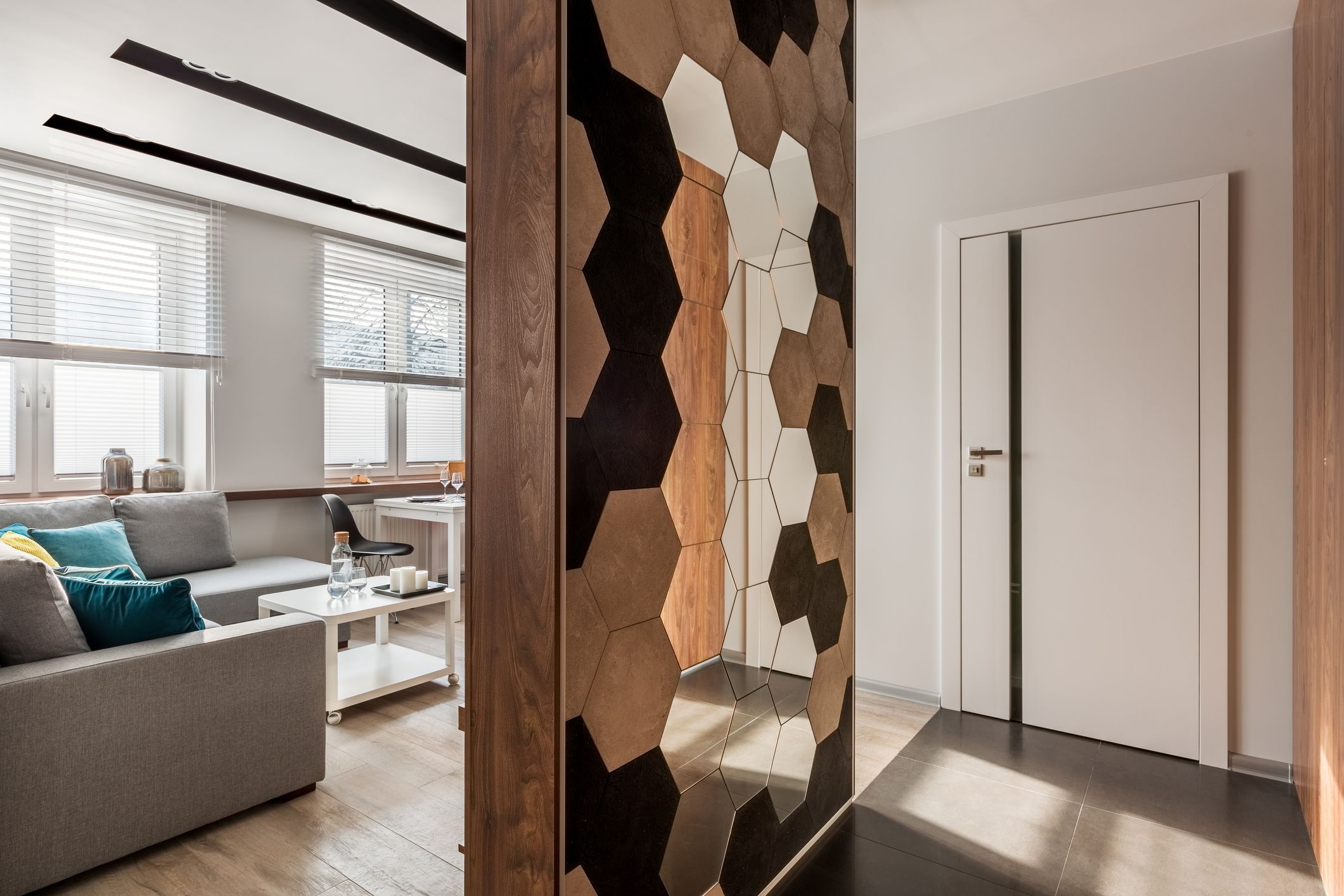 Medio tabique decorativo como alternativa a puertas para separar salón y recibidor