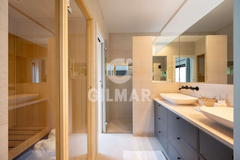 Baño principal con doble lavabo, ducha y sauna en chalet en Madrid situado en Ciudalcampo.
