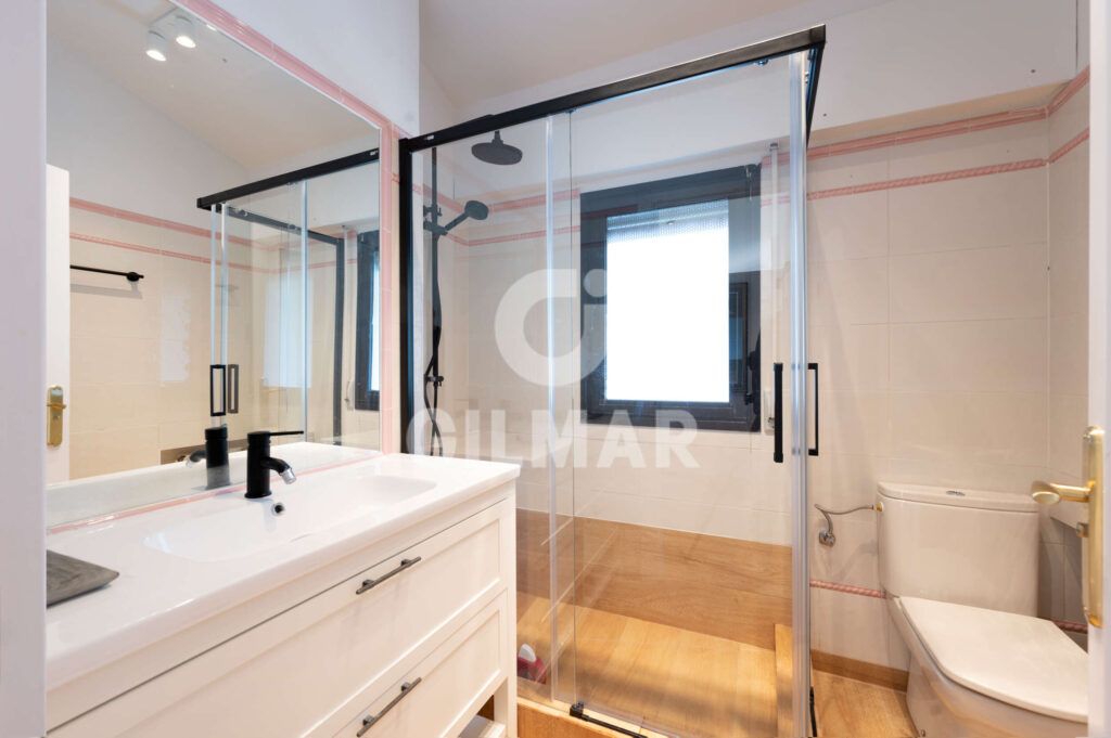 Baño de servicio con ducha y ventana en chalet en Madrid situado en Ciudalcampo.