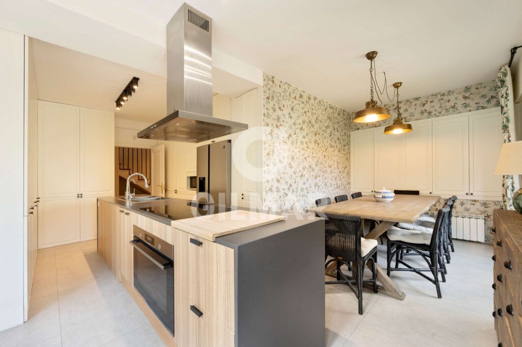 Cocina con isla central y zona office en chalet en Madrid ubicado en Ciudalcampo.