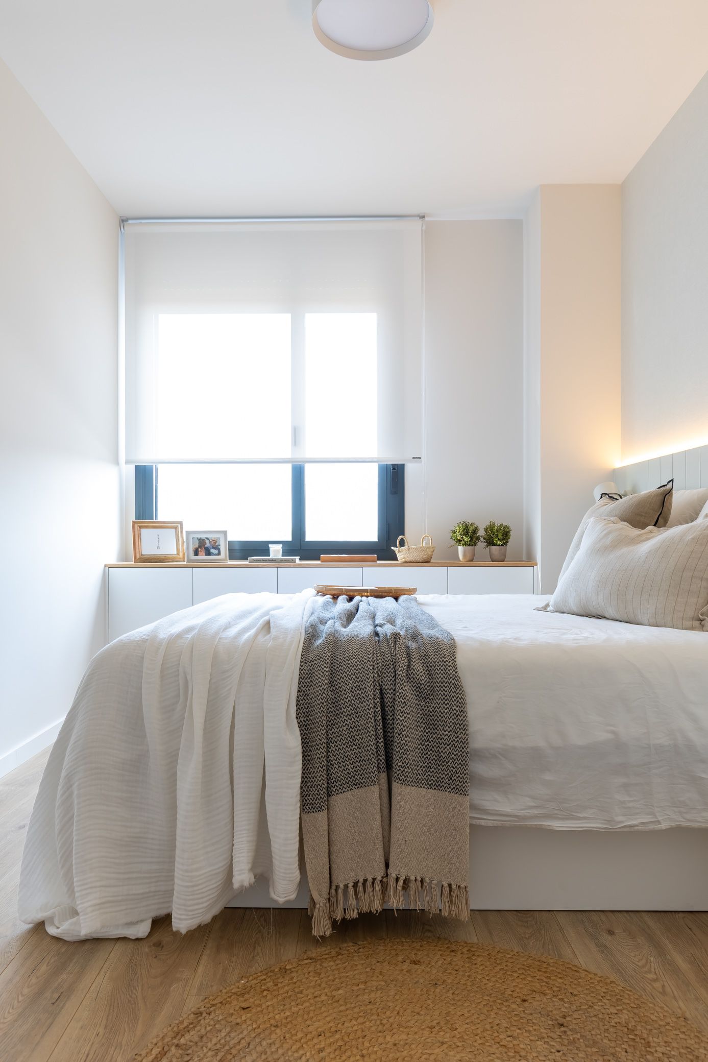 Dormitorio con almacenaje integrado bajo ventana para optimizar espacio en familias que crecen