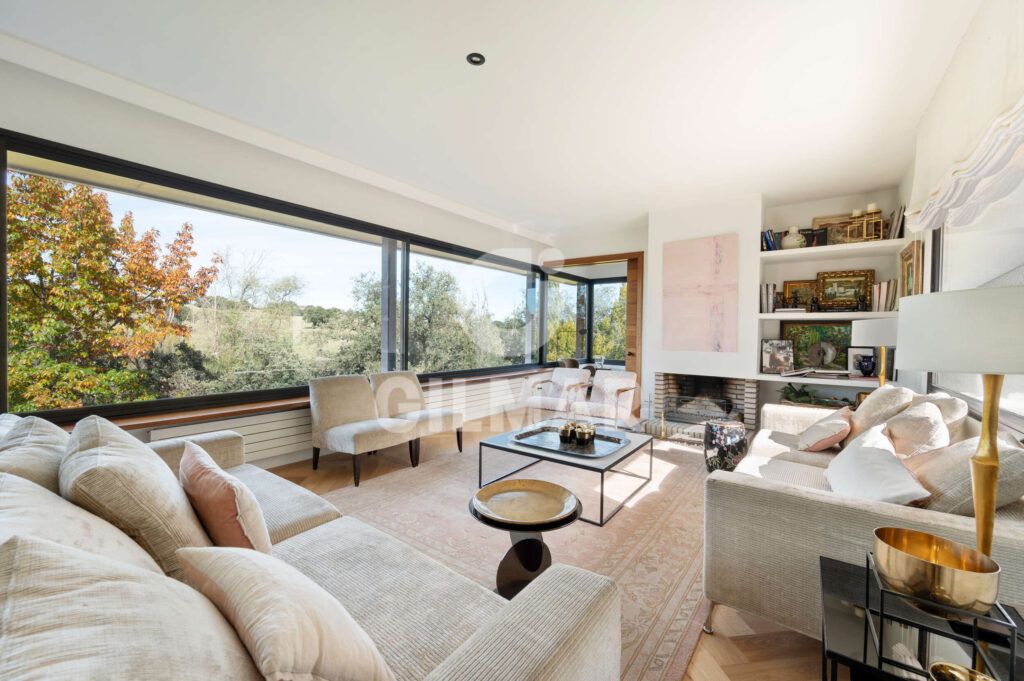 Salón panorámico con grandes ventanales y vistas al paisaje en chalet en Madrid en Ciudalcampo.