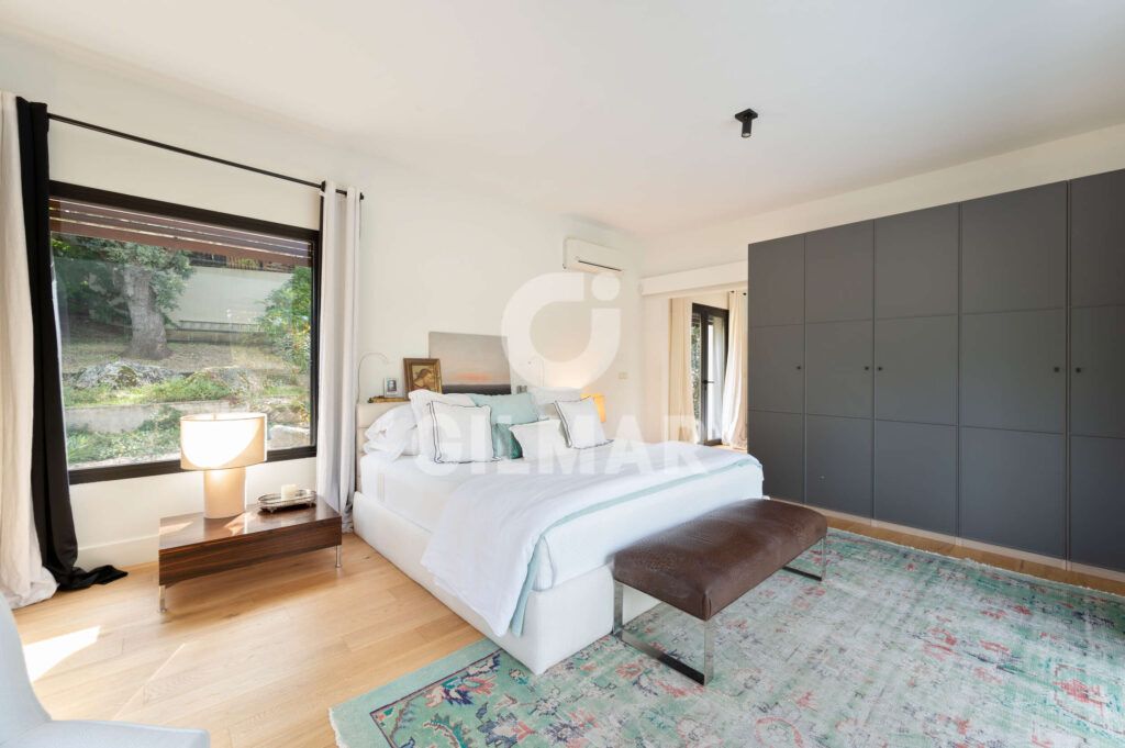 Suite principal con armarios empotrados y grandes ventanales en chalet en Madrid en Ciudalcampo.