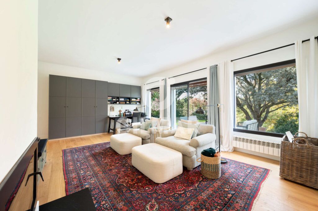 Zona de trabajo con escritorio y grandes ventanales en chalet en Madrid situado en Ciudalcampo.