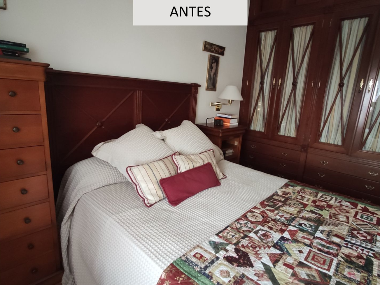 Dormitorio antes de reforma en Barcelona con muebles de madera oscura, cabecero clásico y decoración recargada