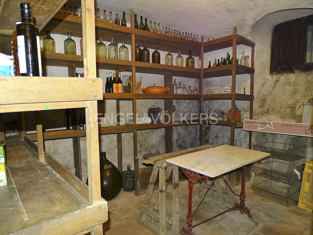 Bodega en casa señorial en Vilassar de Dalt con estanterías de vino y botellas antiguas