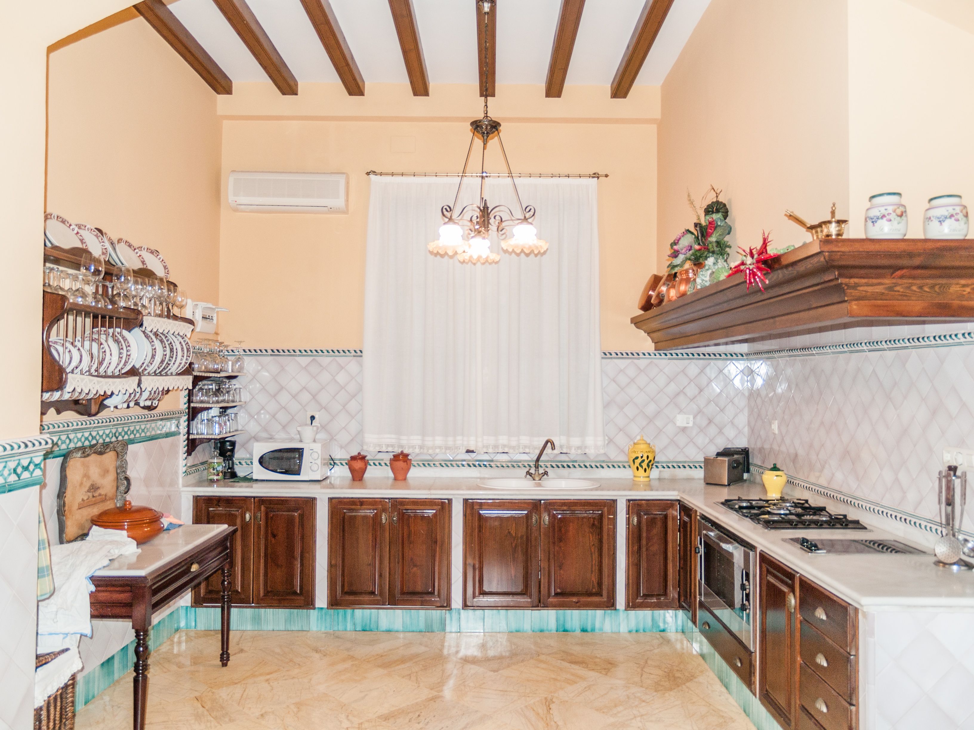 Cocina de casa de lujo en Huelva con muebles de madera, azulejos decorativos y estilo andaluz tradicional