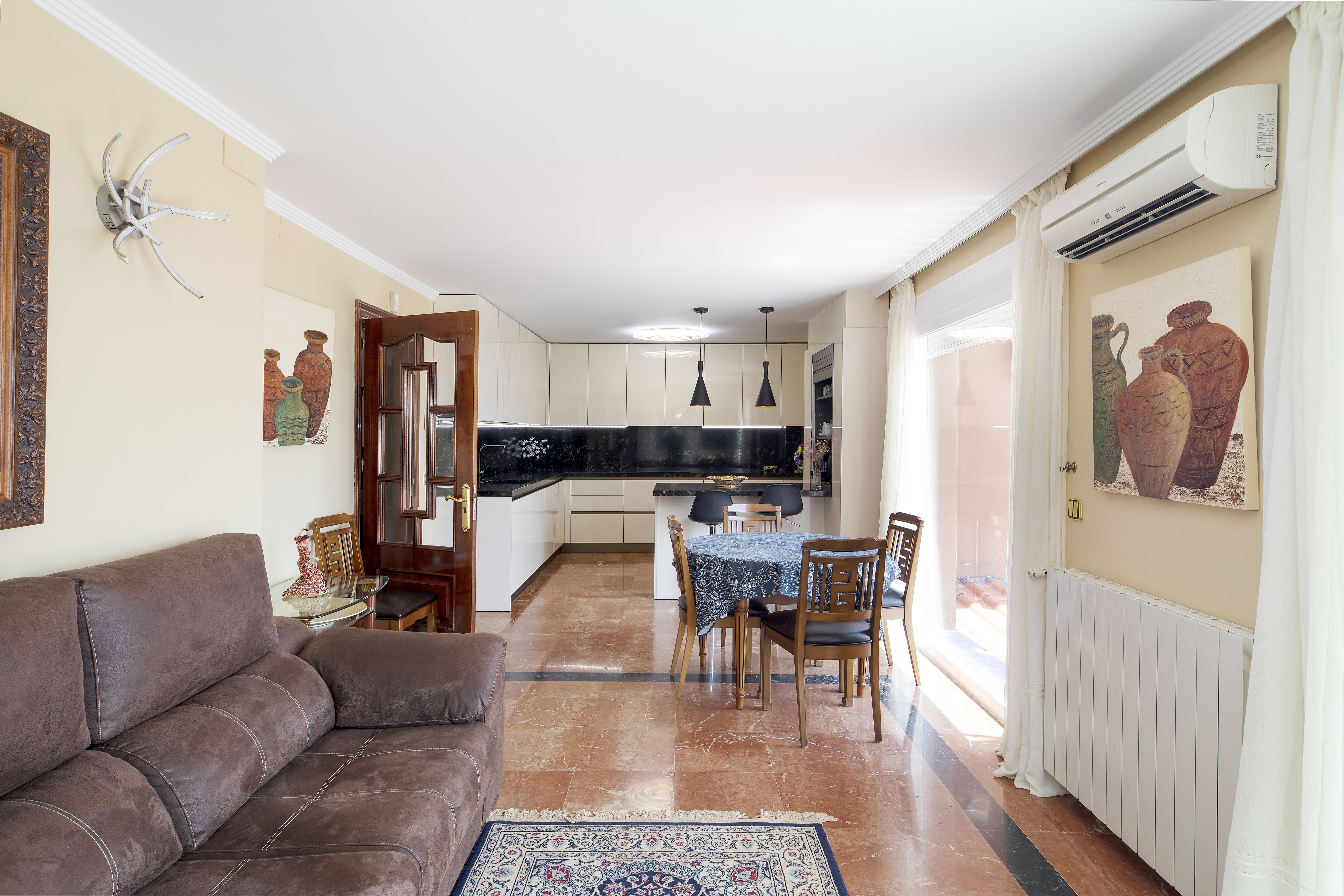 Cocina con office y zona de estar en chalet de lujo en Málaga con comedor diario y luz natural