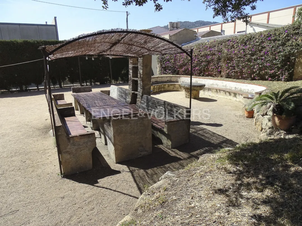 Comedor exterior con sombra en casa señorial en Vilassar de Dalt en zona ajardinada