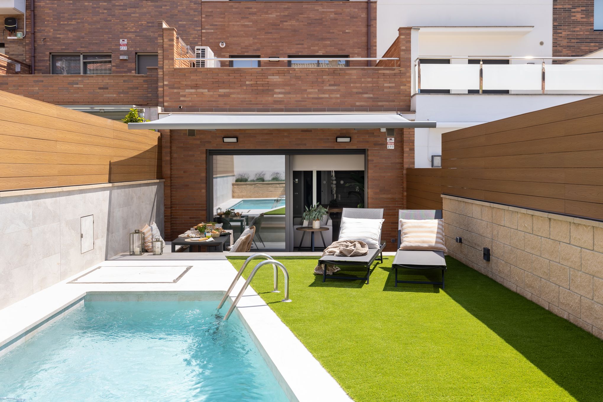 Terraza con piscina y zona de descanso ideal para cómo decorar la casa esta primavera creando un rincón exterior acogedor