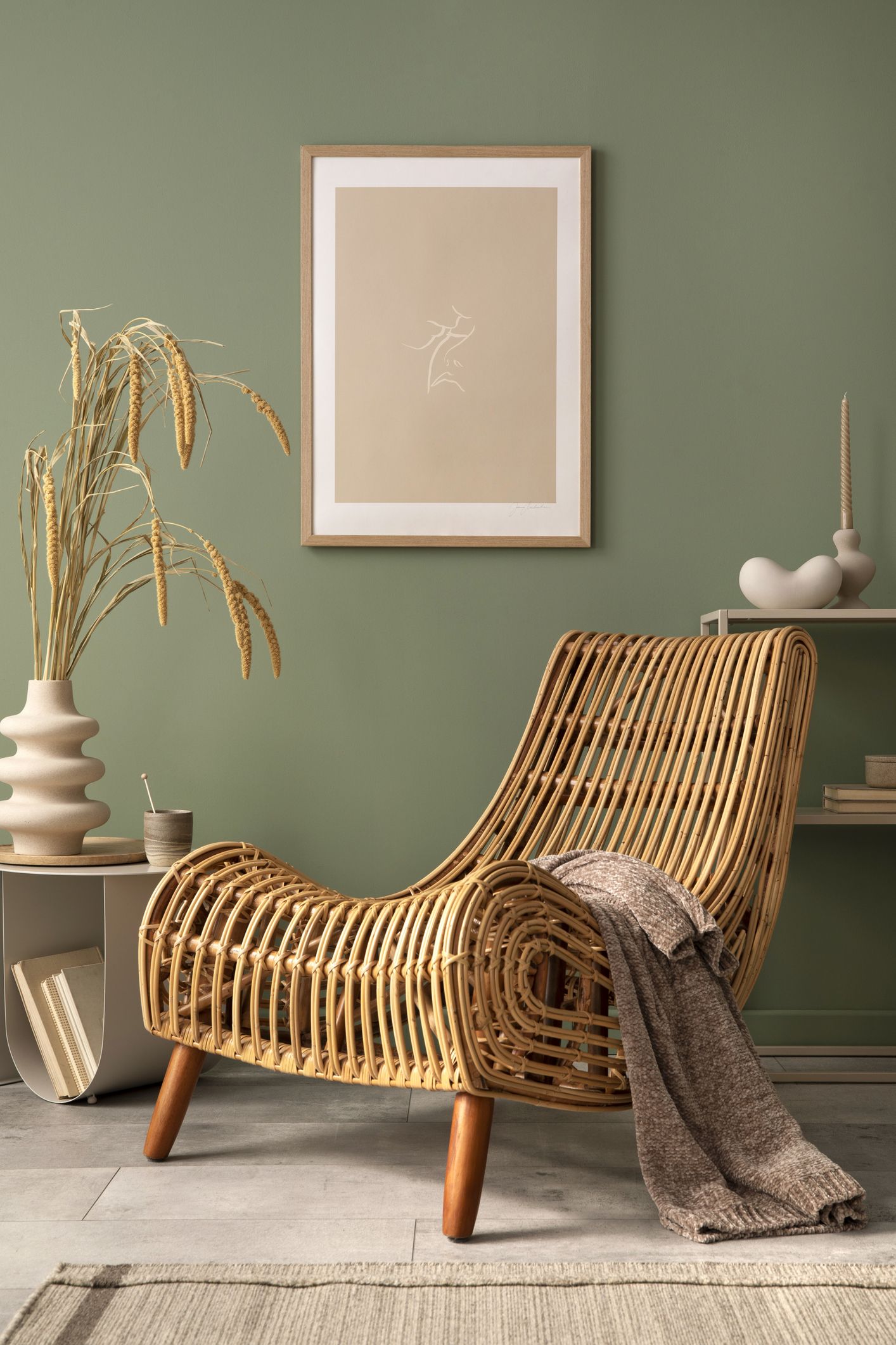 Rincón de lectura en casa con butaca de ratán, manta, ilustración y decoración natural en tonos neutros