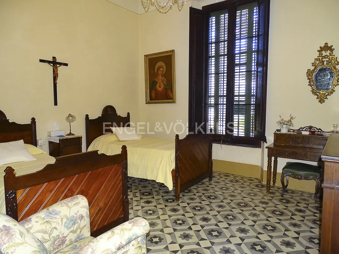 Dormitorio en casa señorial en Vilassar de Dalt con suelo hidráulico y mobiliario clásico