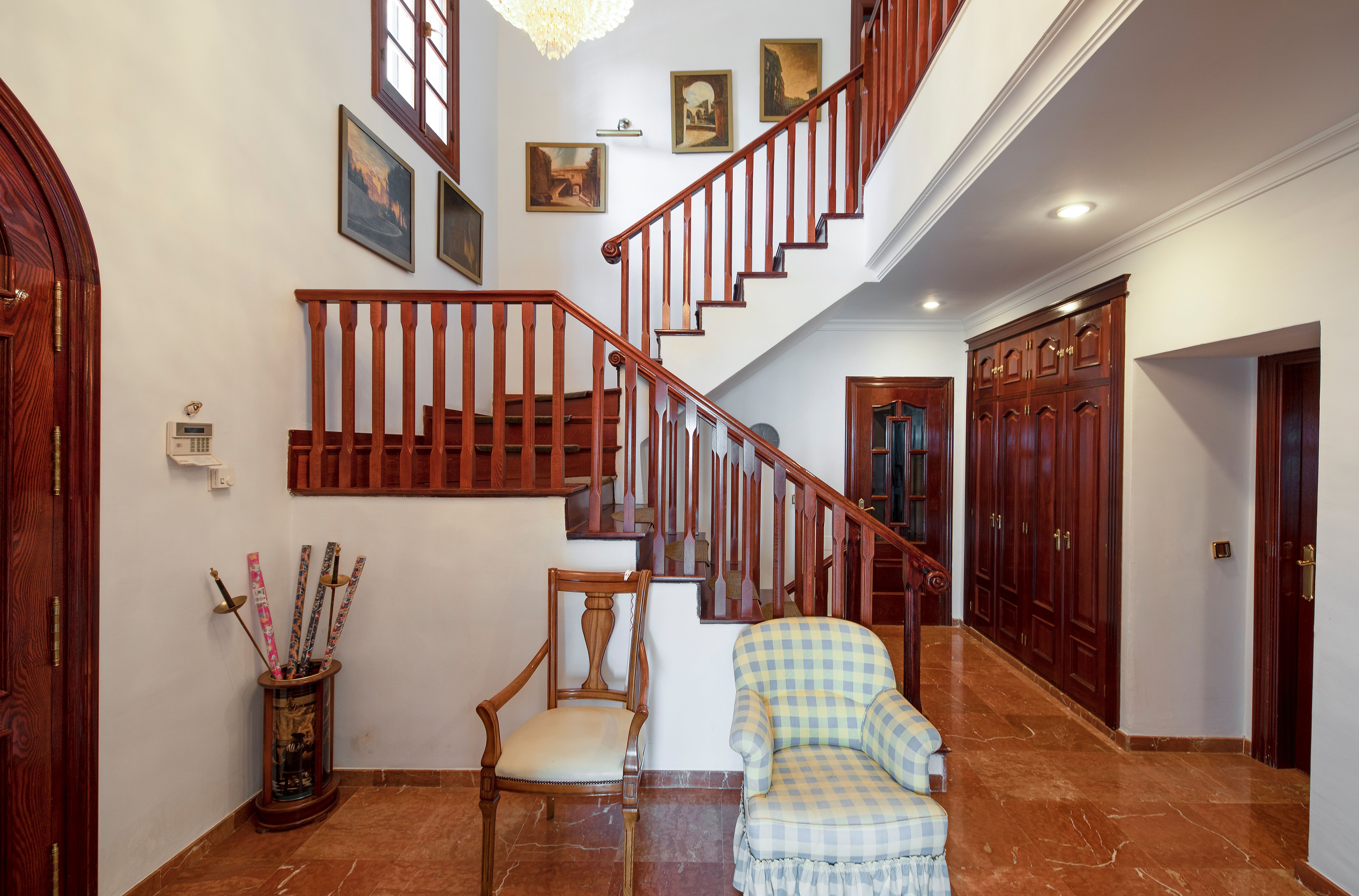 Escalera interior de chalet de lujo en Málaga con madera noble y hall de entrada en Pinares de San Antón