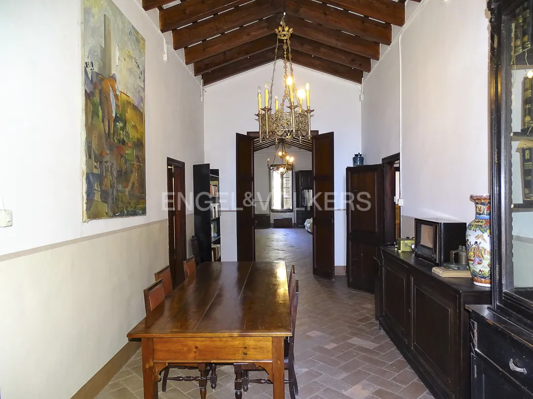 Espacio de paso en casa señorial en Vilassar de Dalt con vigas de madera y mobiliario clásico