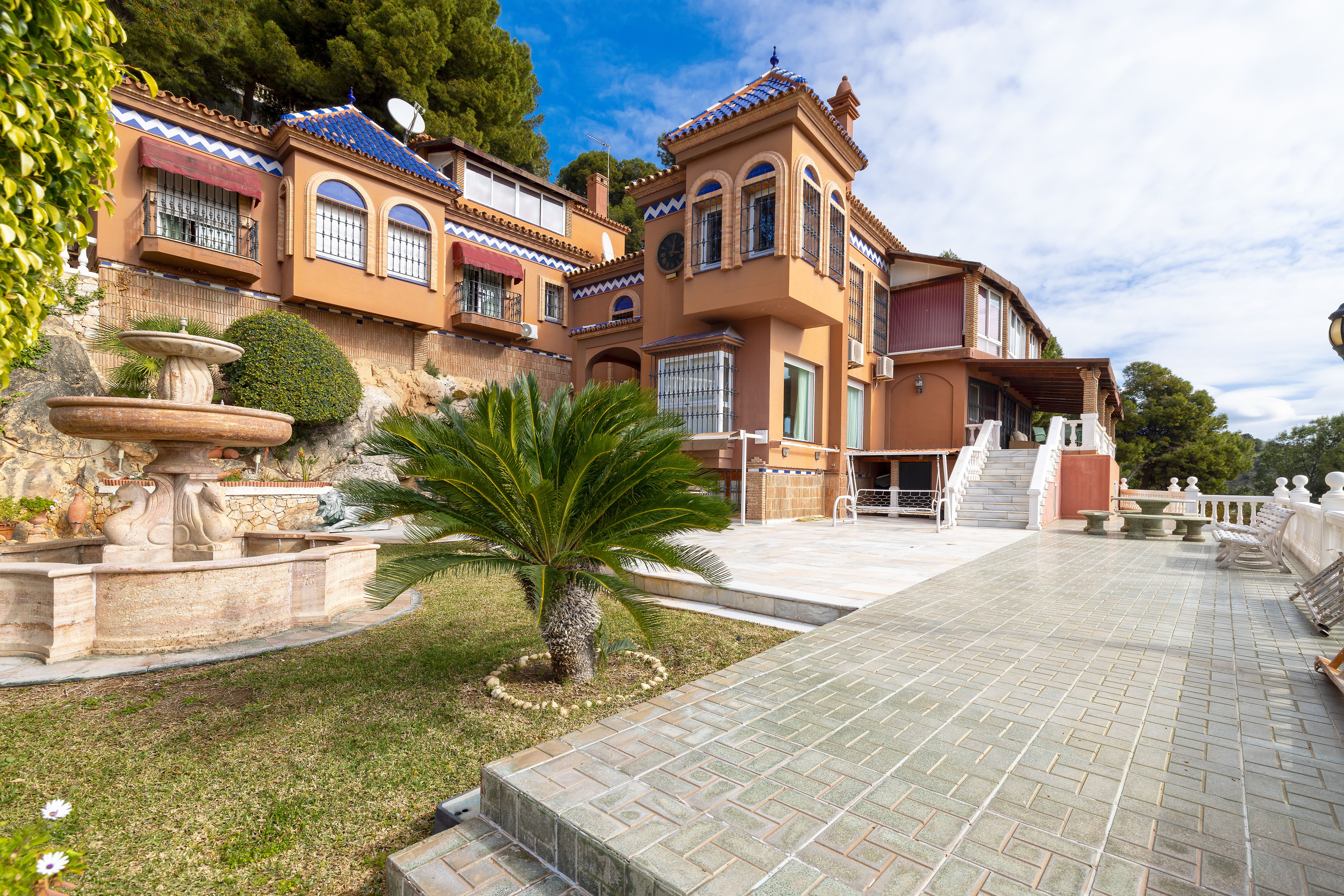 Fachada posterior de chalet de lujo en Málaga con porche, jardín y terraza en Pinares de San Antón