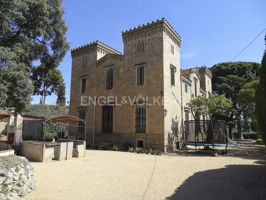Jardín de casa señorial en Vilassar de Dalt con patio exterior y torres de piedra