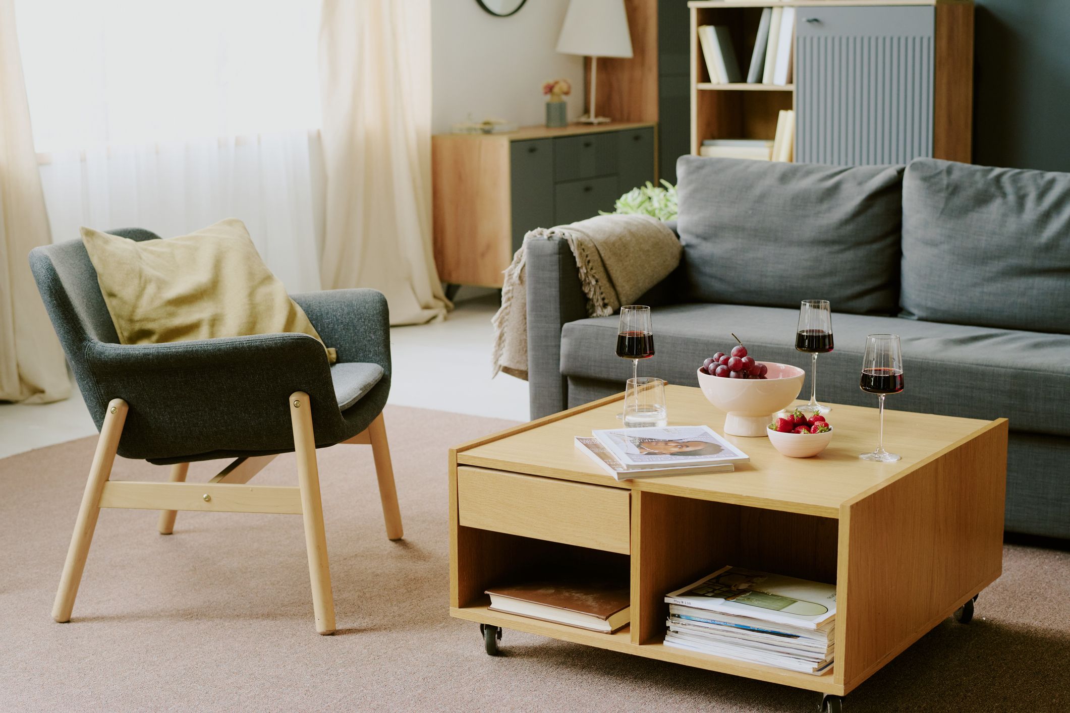 Módulo abierto tipo cubo usado como mesa auxiliar en el salón junto al sofá con espacio de almacenaje inferior