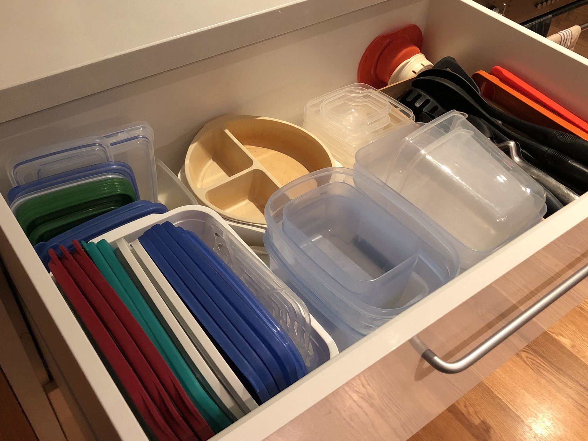 Tapas de tápers organizadas en vertical dentro de un cajón de cocina con sistema tipo archivo