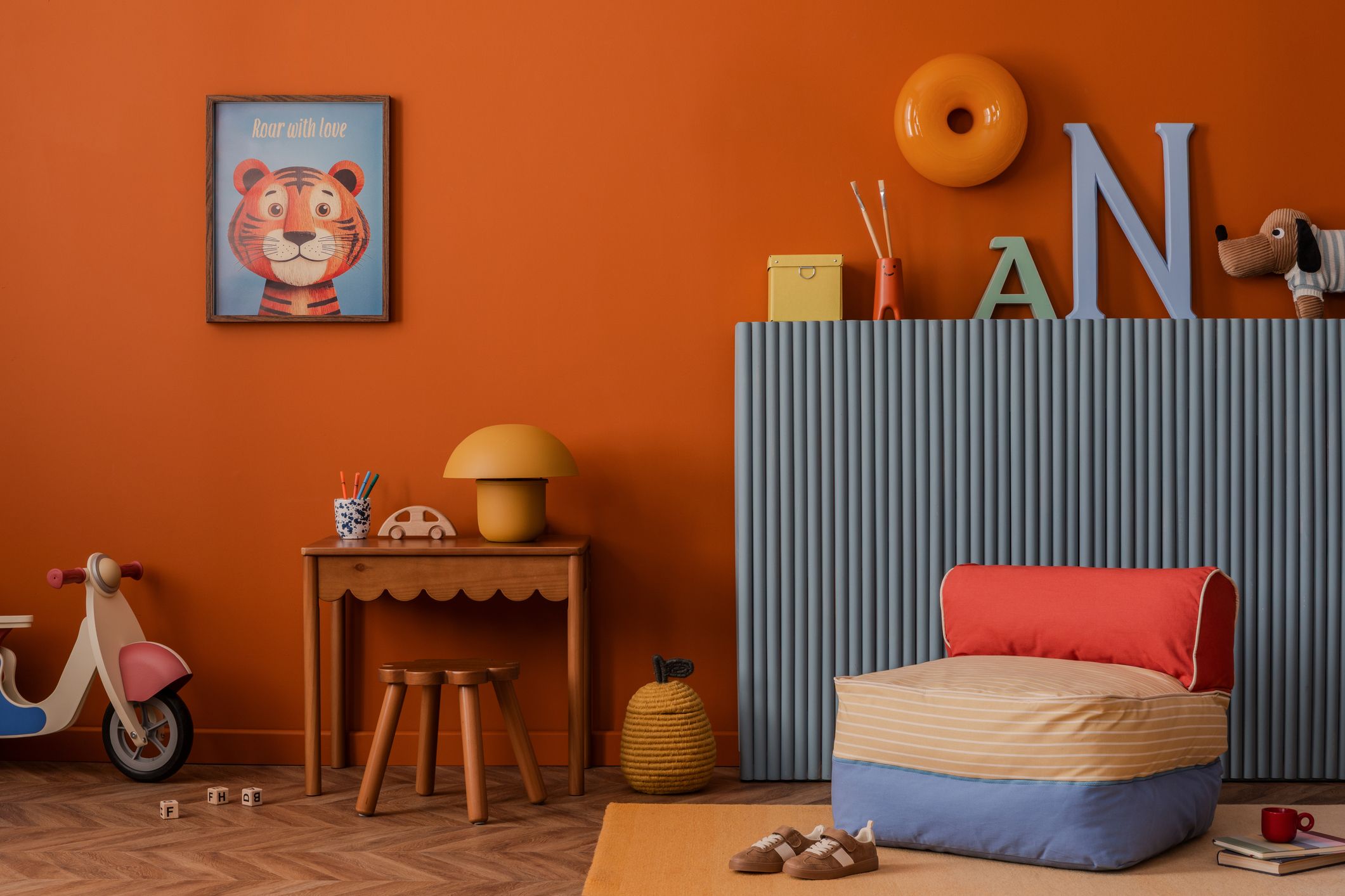 Rincón de lectura infantil en casa con cojín de suelo, muebles bajos, libros y decoración colorida