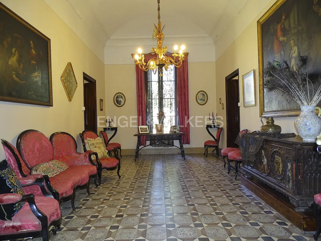 Sala de transición en casa señorial en Vilassar de Dalt con suelo original y mobiliario clásico