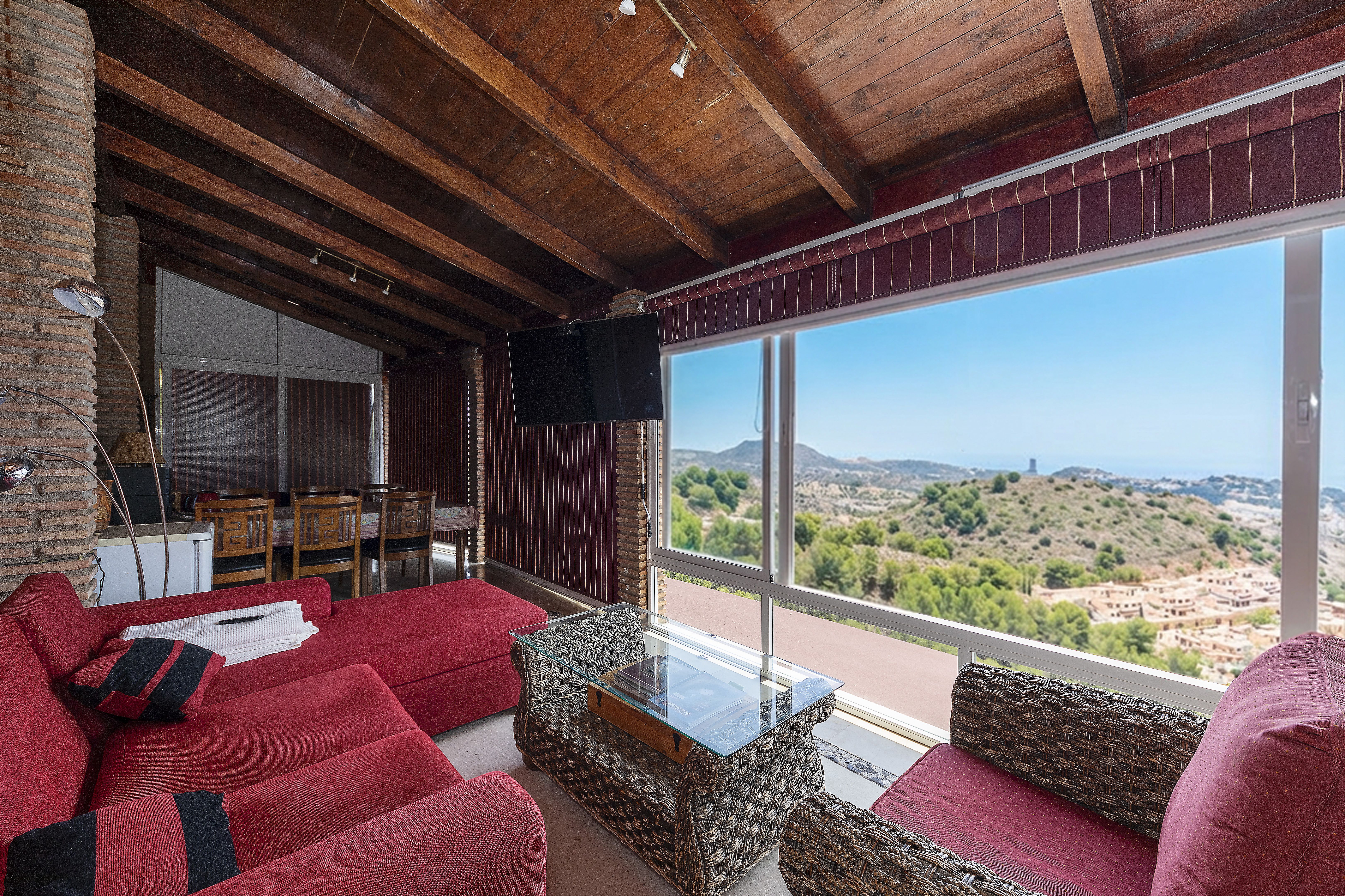 Segundo salón comedor de chalet de lujo en Málaga con grandes ventanales y vistas al mar Mediterráneo