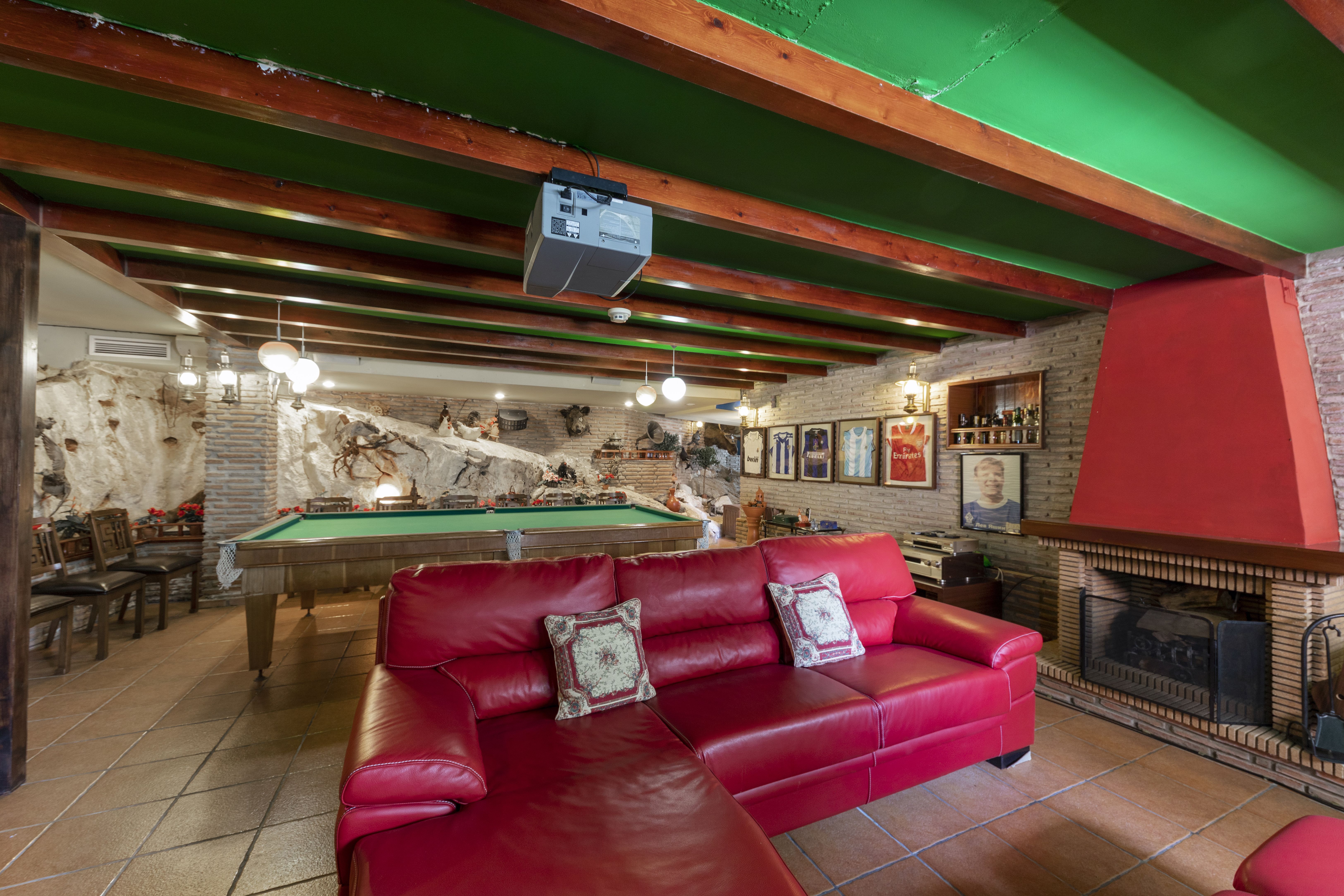Zona de ocio del chalet en Málaga con mesa de billar, chimenea y amplio salón de juegos
