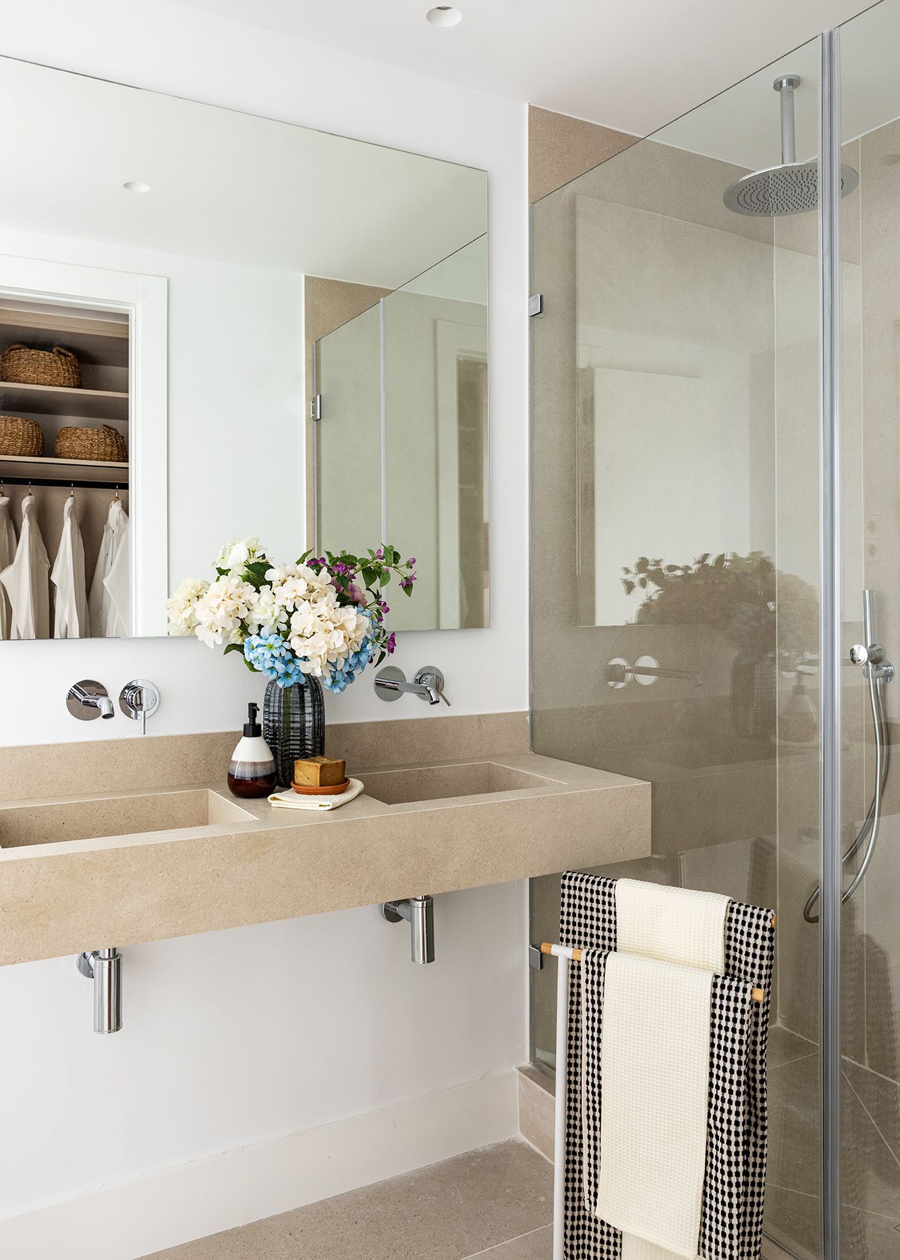 Baño moderno con doble lavabo, ducha de obra y acabados en tonos neutros en una vivienda de Chamberí, diseñado para aumentar el valor percibido de una vivienda.
