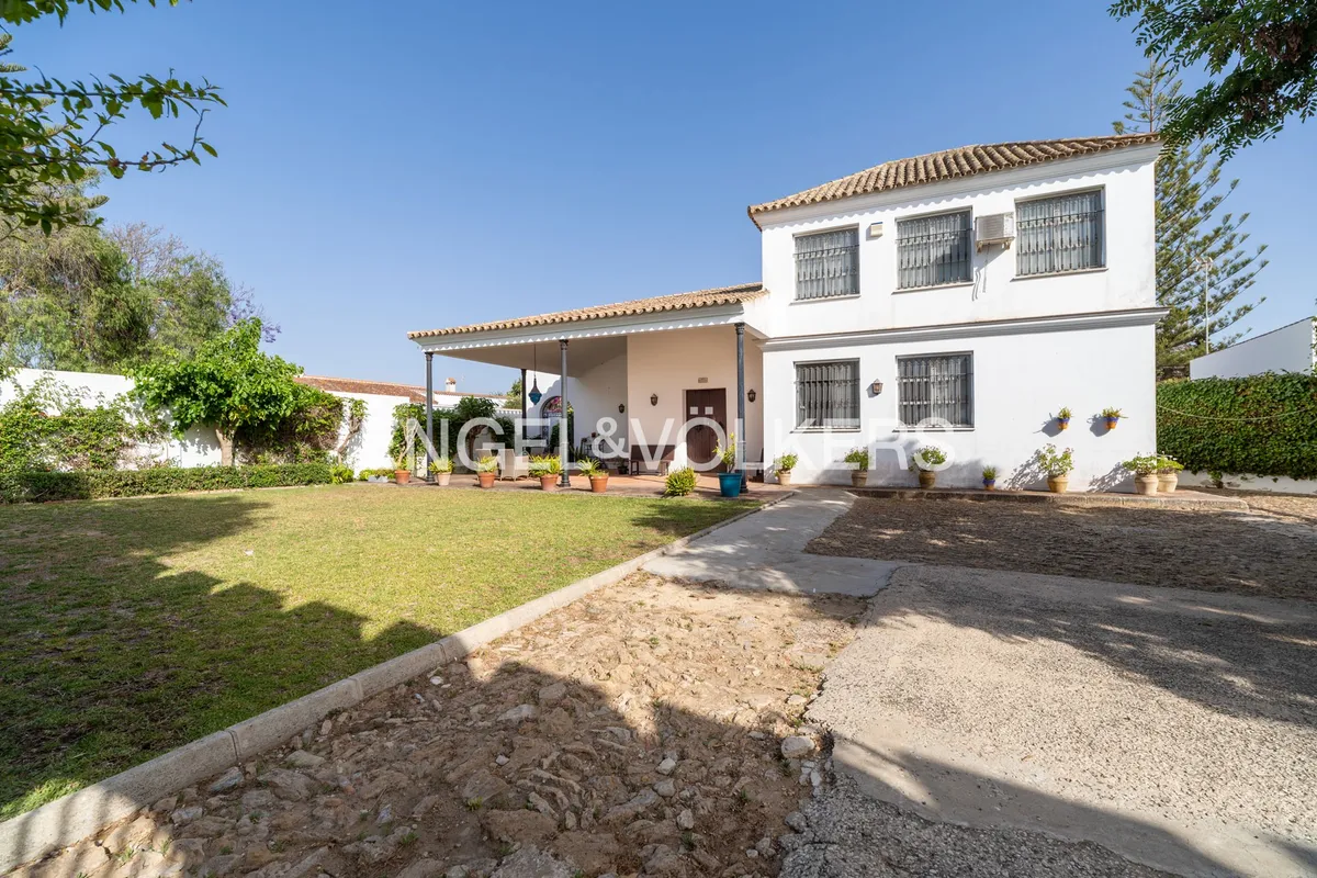 Casa en la playa de Sanlúcar de Barrameda con jardín privado, gran porche cubierto y fachada andaluza tradicional