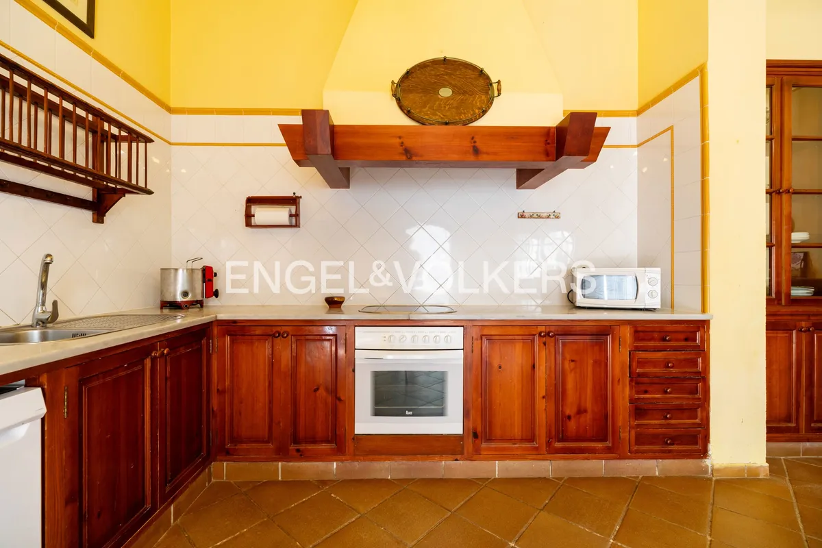 Zona de cocción en cocina de casa en la playa de Sanlúcar de Barrameda con campana tradicional de madera