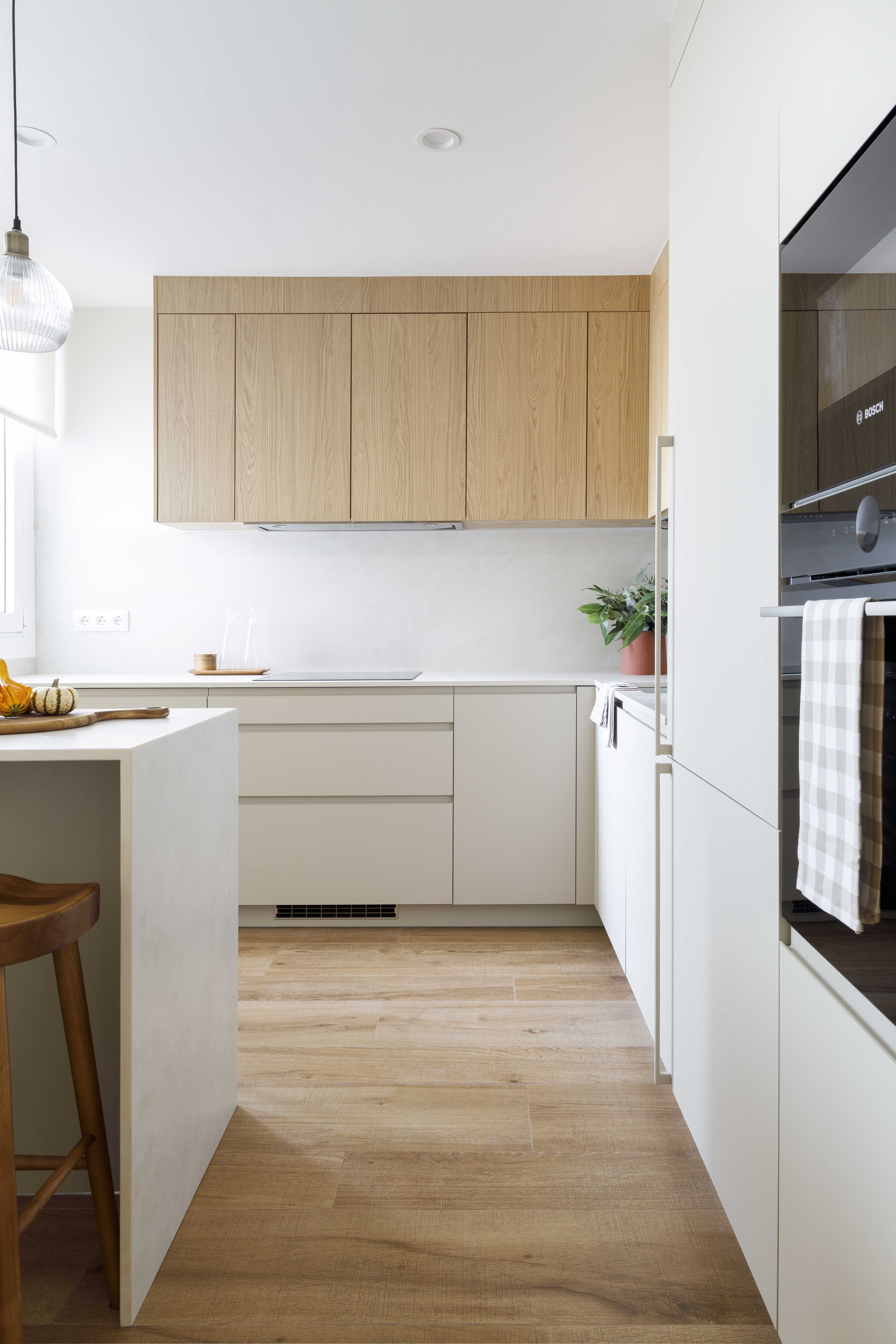 Cocina reformada con muebles de madera clara y distribución funcional en una vivienda familiar