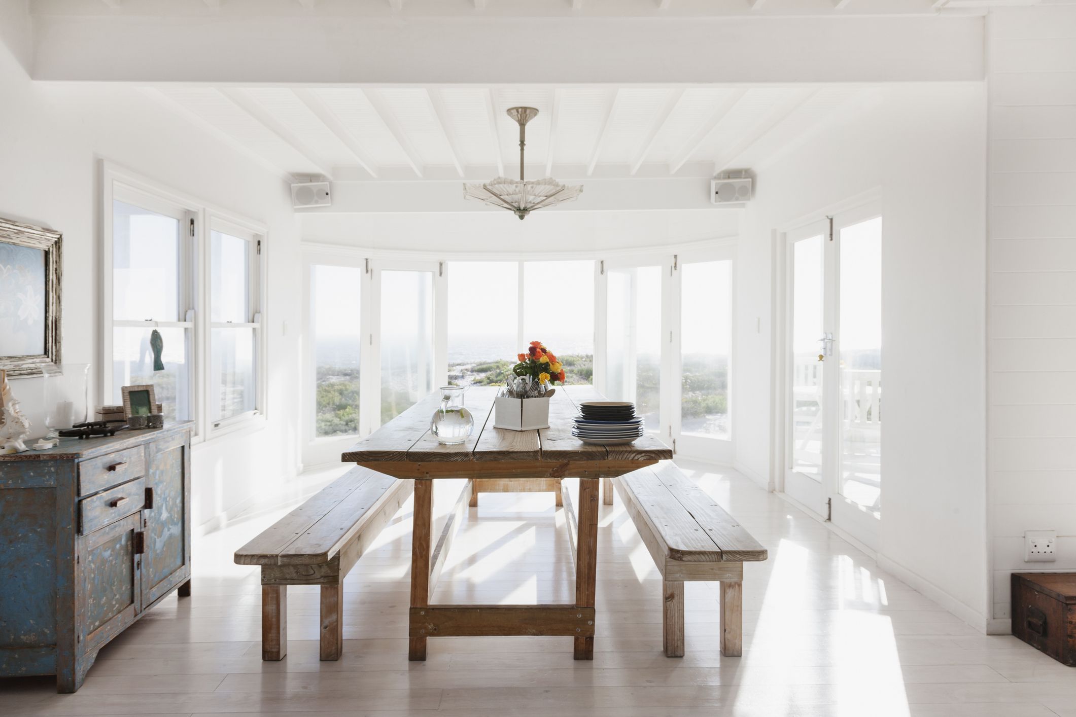 Comedor luminoso con mesa de madera envejecida y decoración coastal inspirado en la casa de El verano en que me enamoré