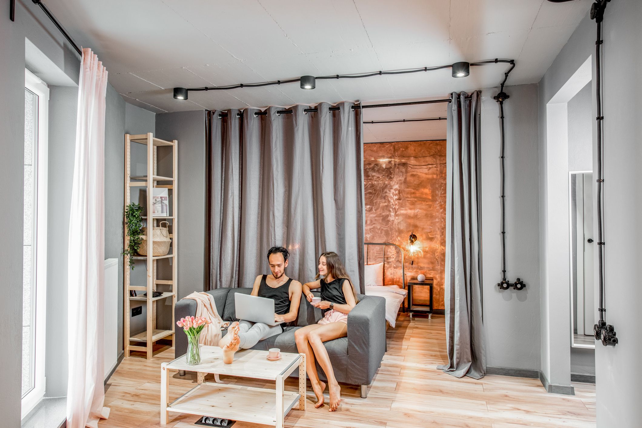 Cortinas de techo para separar ambientes entre salón y dormitorio en un loft moderno