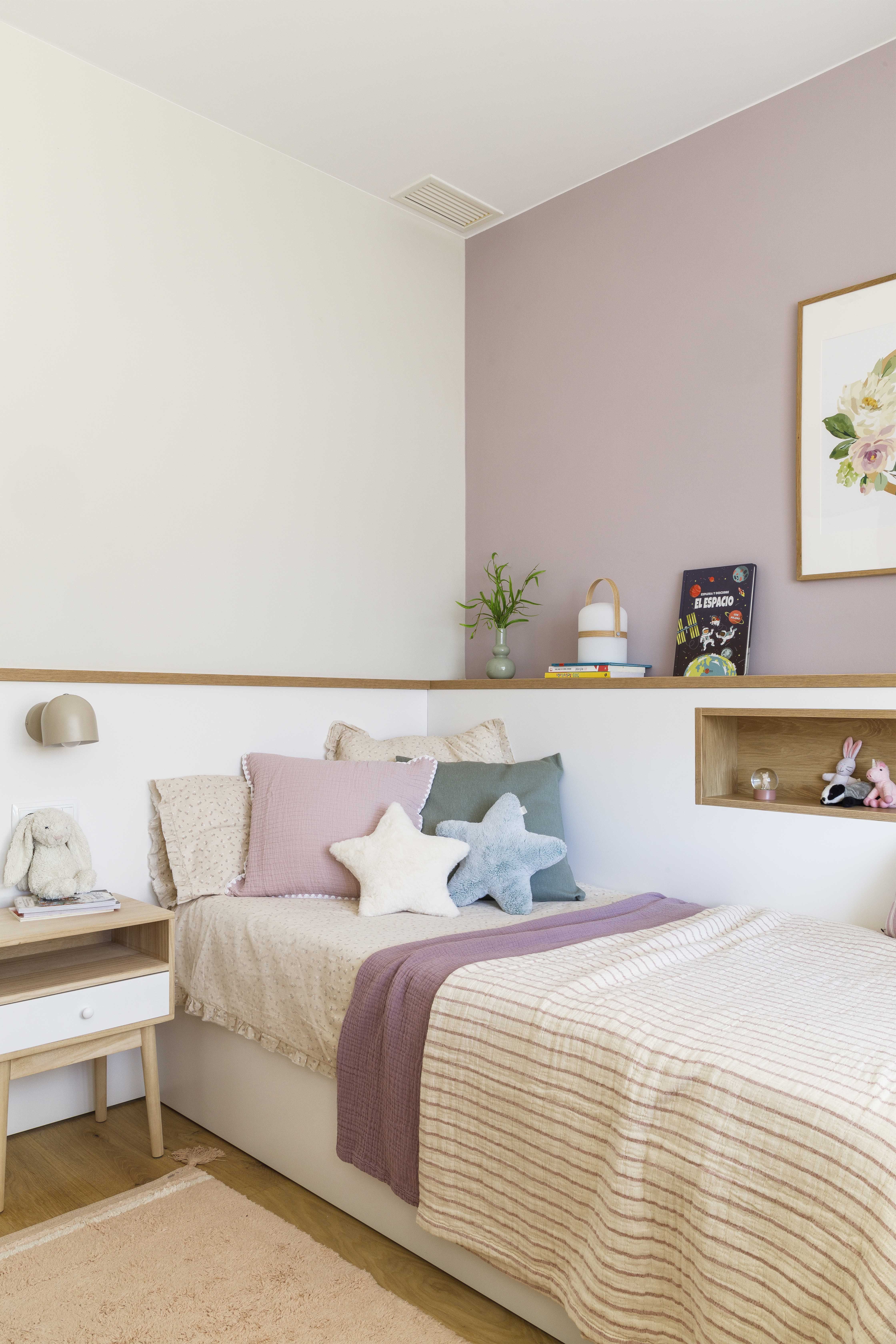 Habitación infantil de niña con cama individual, textiles en tonos rosa y decoración cálida