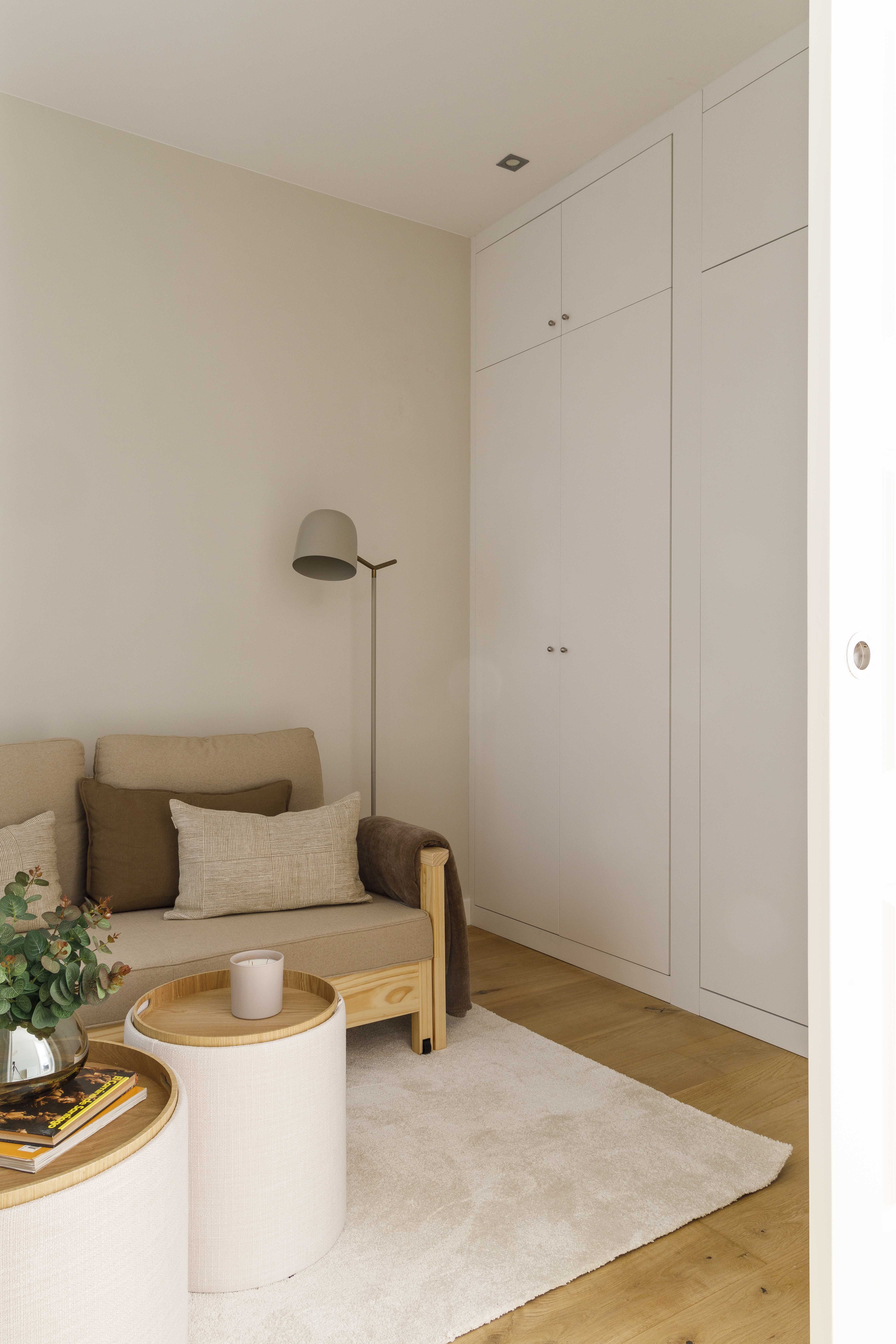 Habitación polivalente con sofá cama y armario a medida en una vivienda familiar reformada