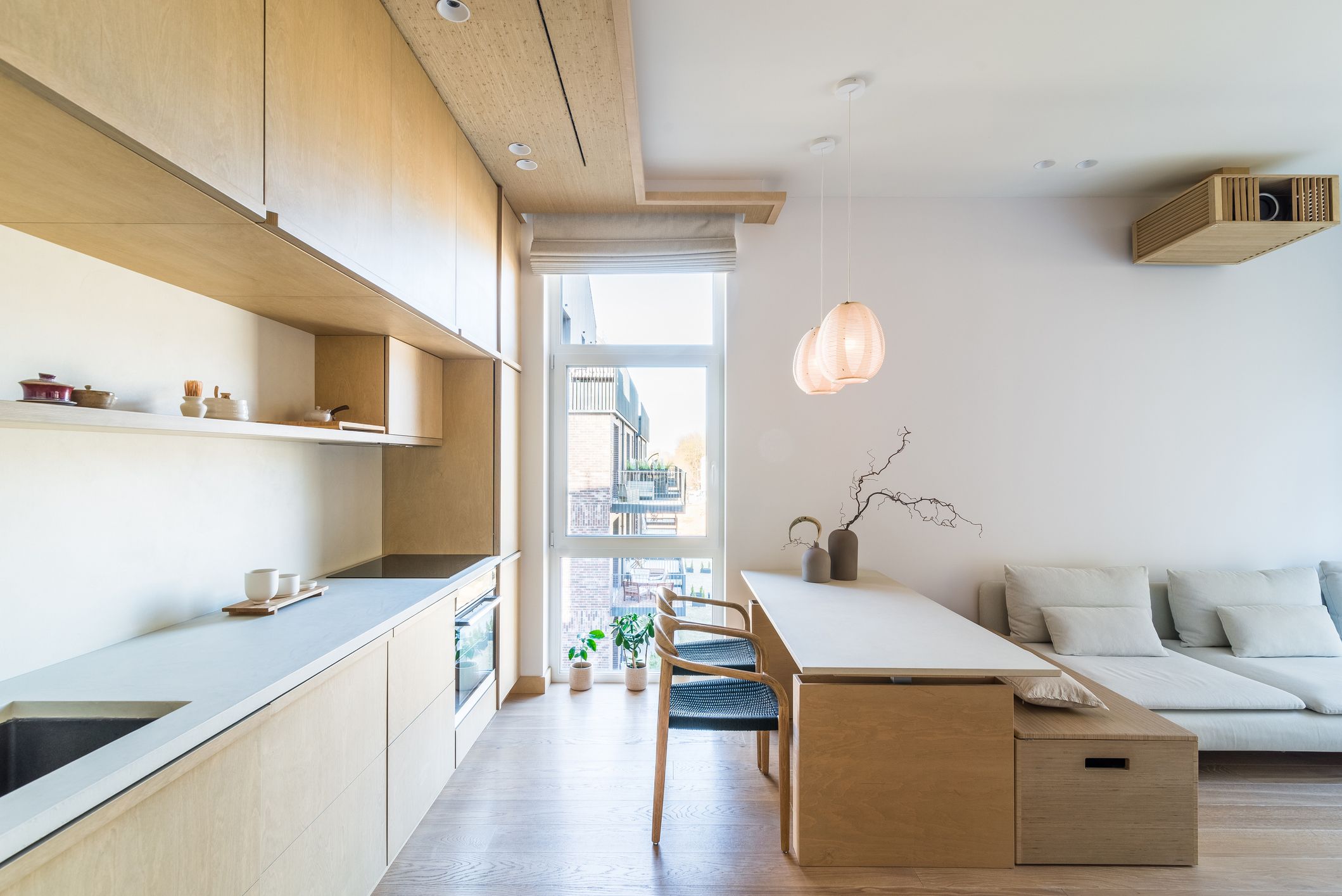 Isla híbrida de cocina con banco y almacenaje para separar ambientes en un espacio abierto