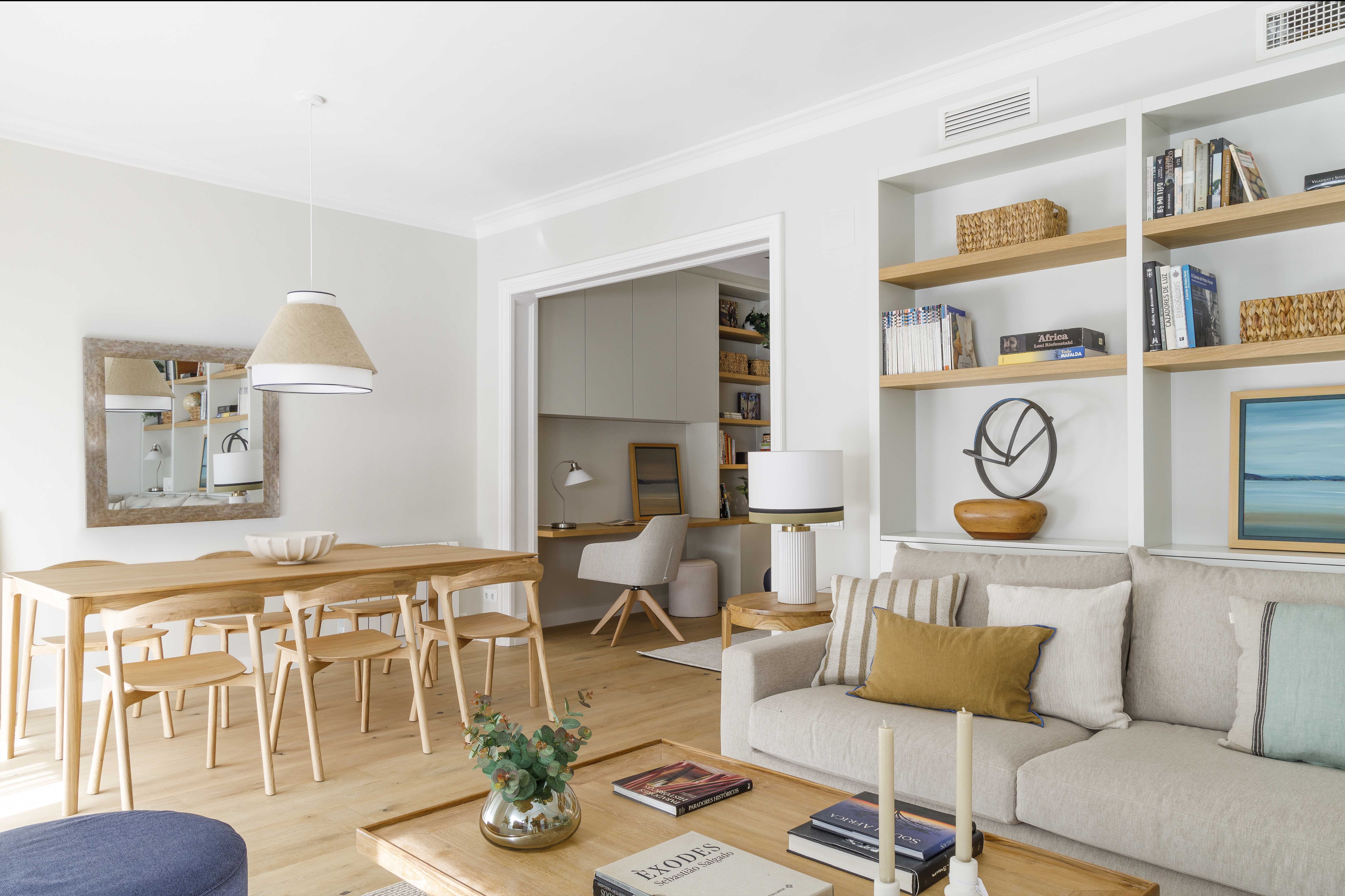 Salón comedor reformado con despacho integrado y estanterías a medida en una vivienda familiar con metros mejor aprovechados