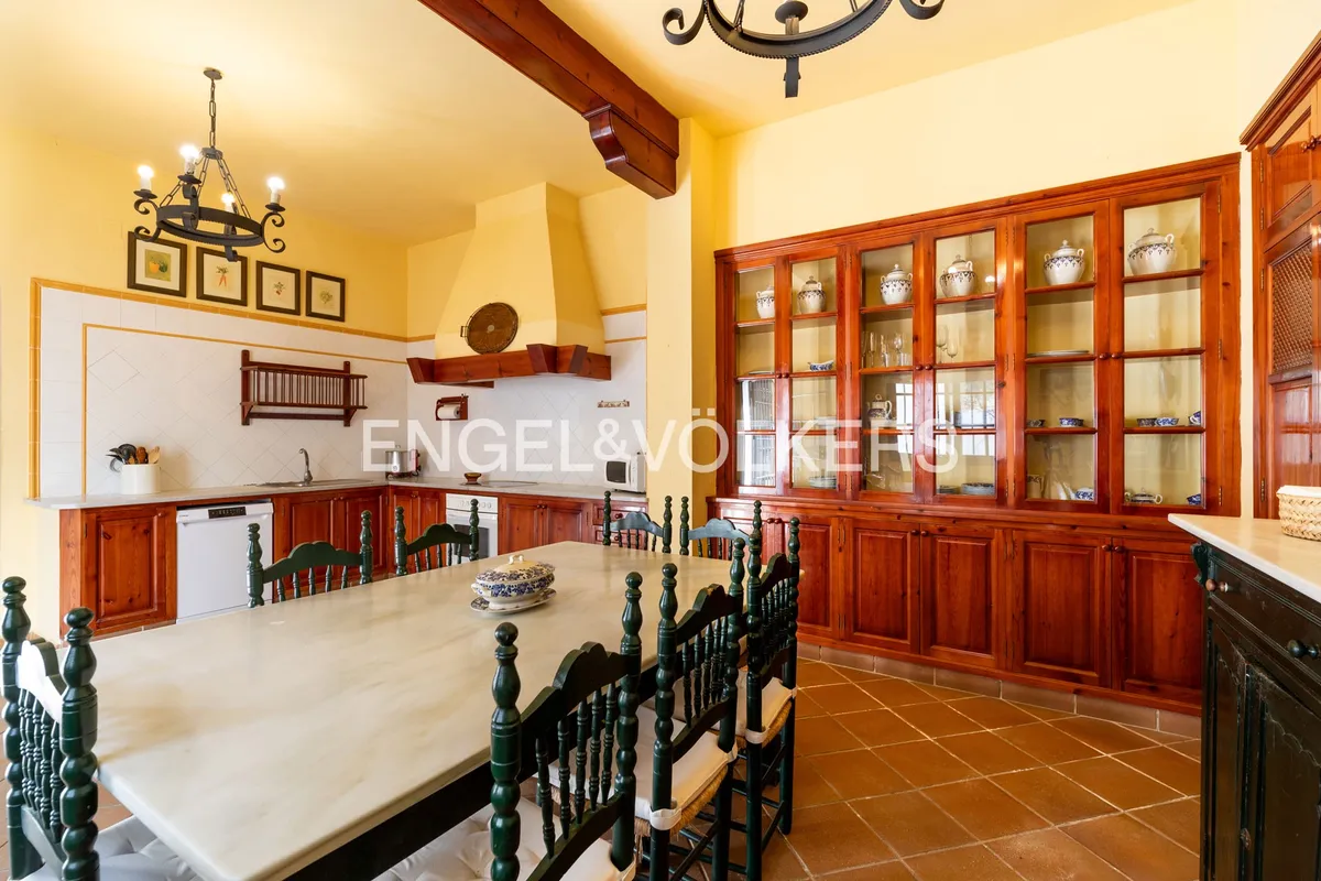 Office de cocina en casa de Sanlúcar de Barrameda con alacenas de madera y comedor tradicional andaluz