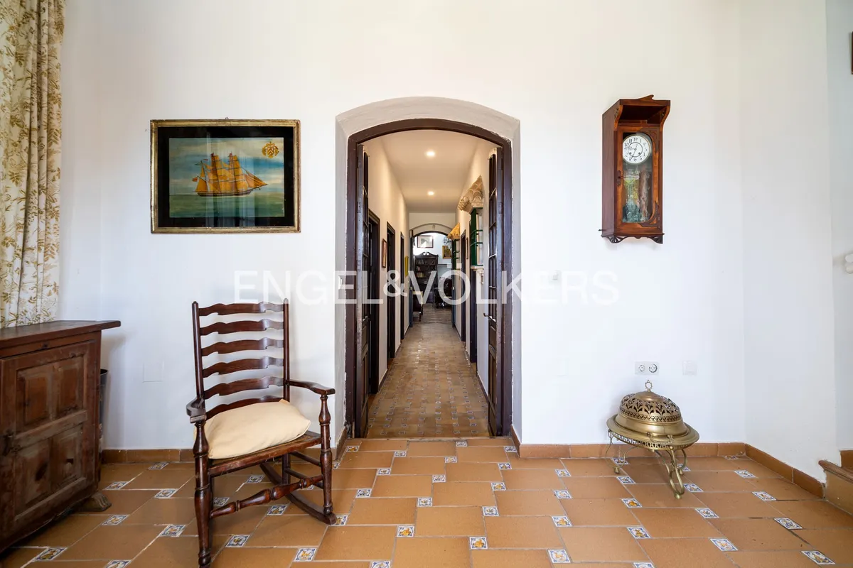 Pasillo interior de casa en la playa de Sanlúcar de Barrameda con arcos y suelos tradicionales andaluces