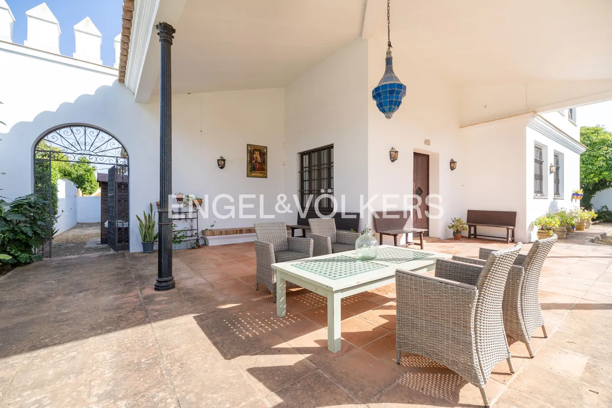 Gran porche cubierto de casa en la playa de Sanlúcar de Barrameda con columnas negras y terraza andaluza