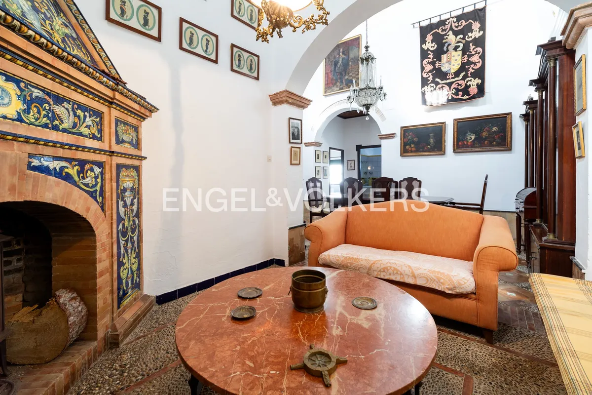 Sala de estar de casa en la playa de Sanlúcar de Barrameda con chimenea andaluza de azulejos y techos altos