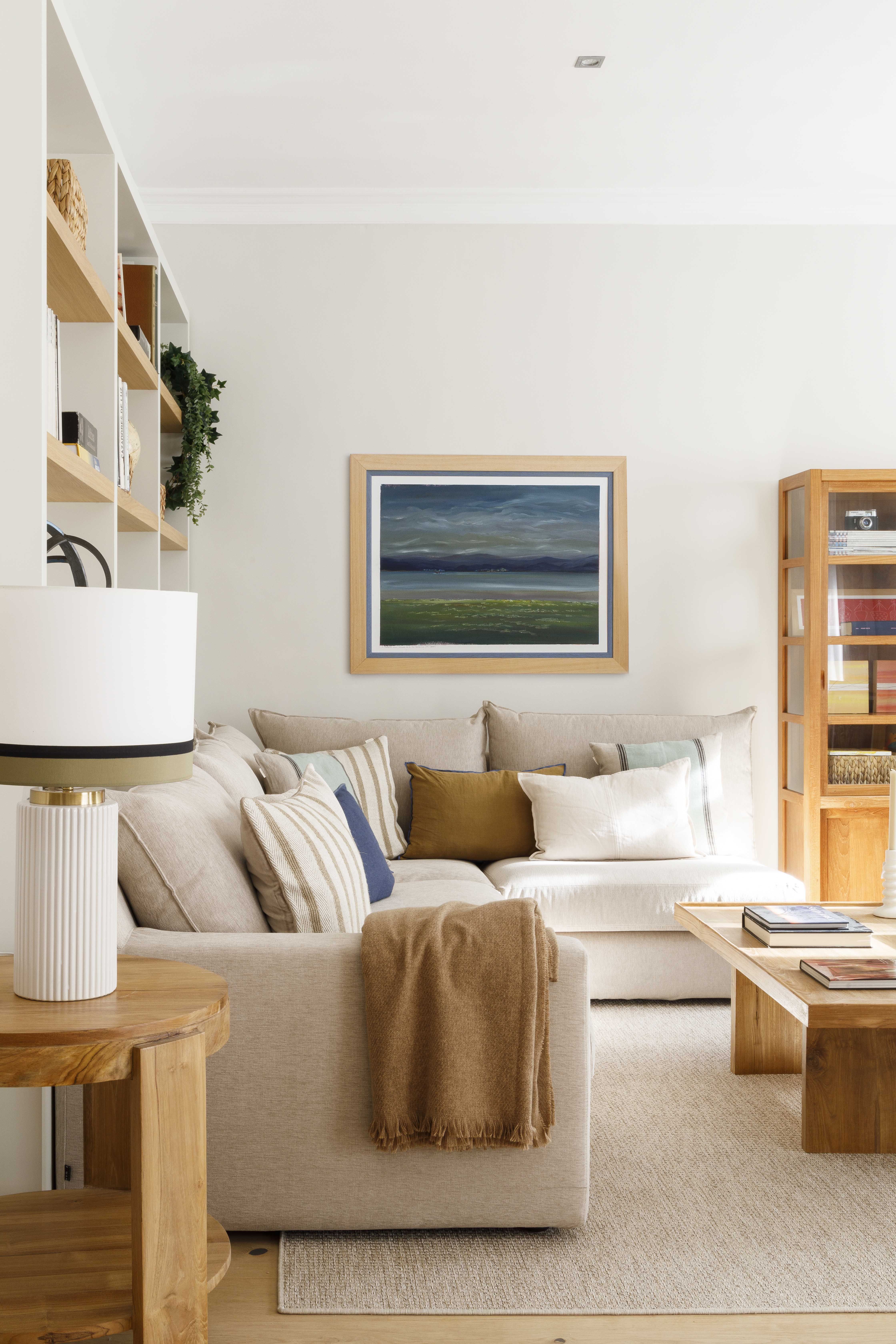 Salón comedor reformado con luz natural, muebles de madera y textiles neutros en una vivienda familiar