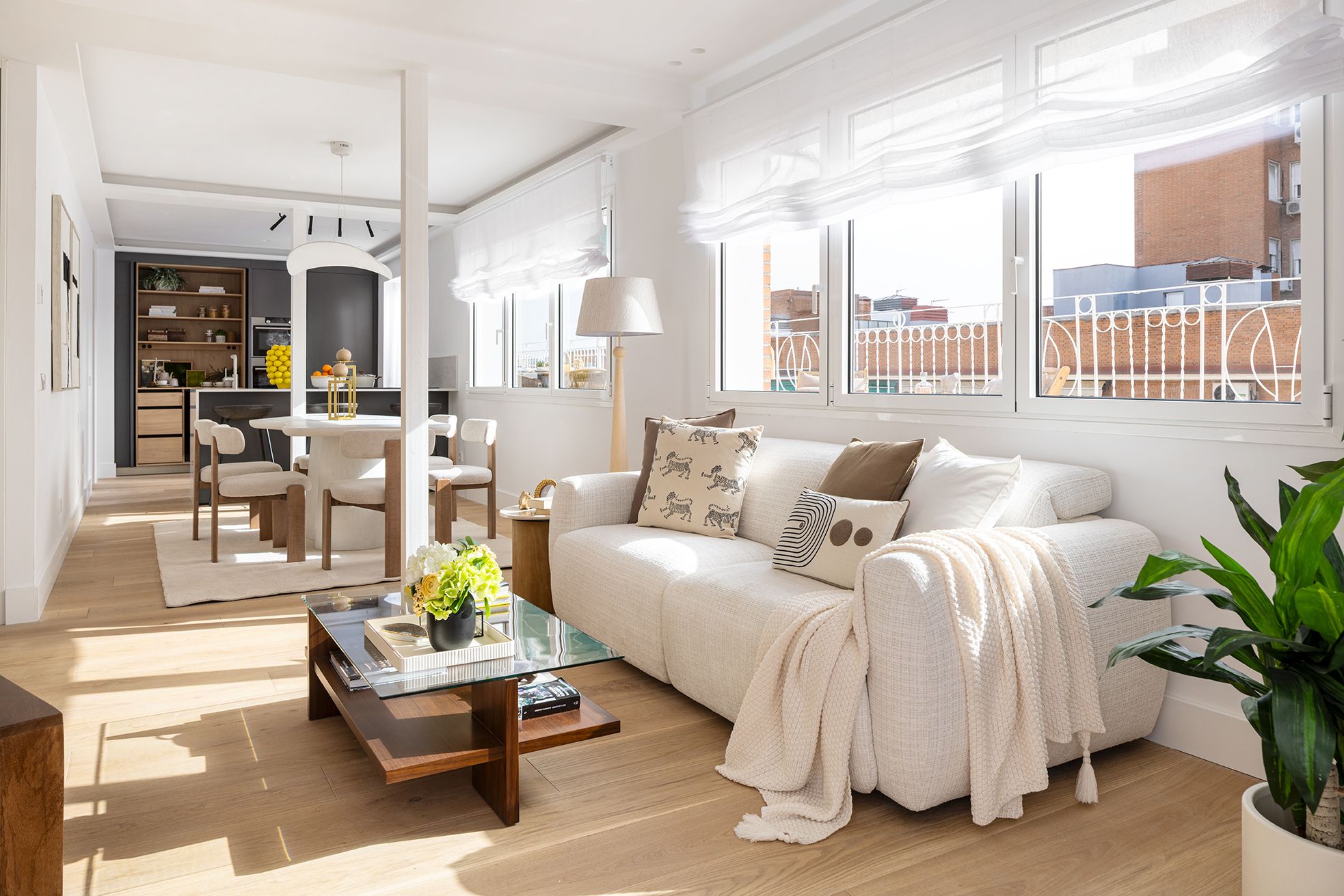 Salón luminoso con comedor integrado y grandes ventanales en una vivienda de Chamberí, diseñado para aumentar el valor percibido de una vivienda mediante una distribución abierta y una decoración neutra.