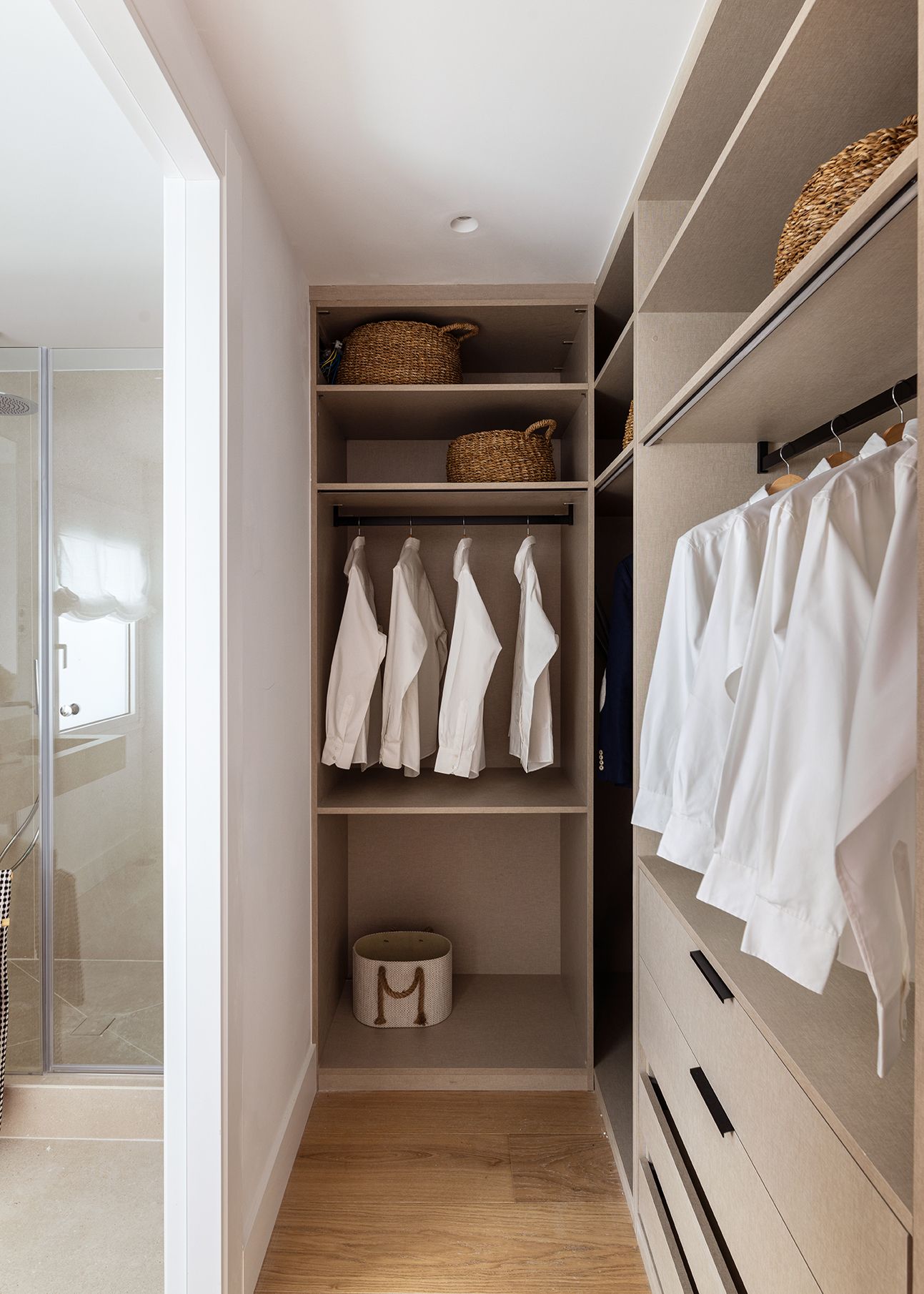 Vestidor abierto con almacenaje organizado, cajoneras y barras para ropa en una vivienda de Chamberí, diseñado para aumentar el valor percibido de una vivienda mediante orden y funcionalidad.