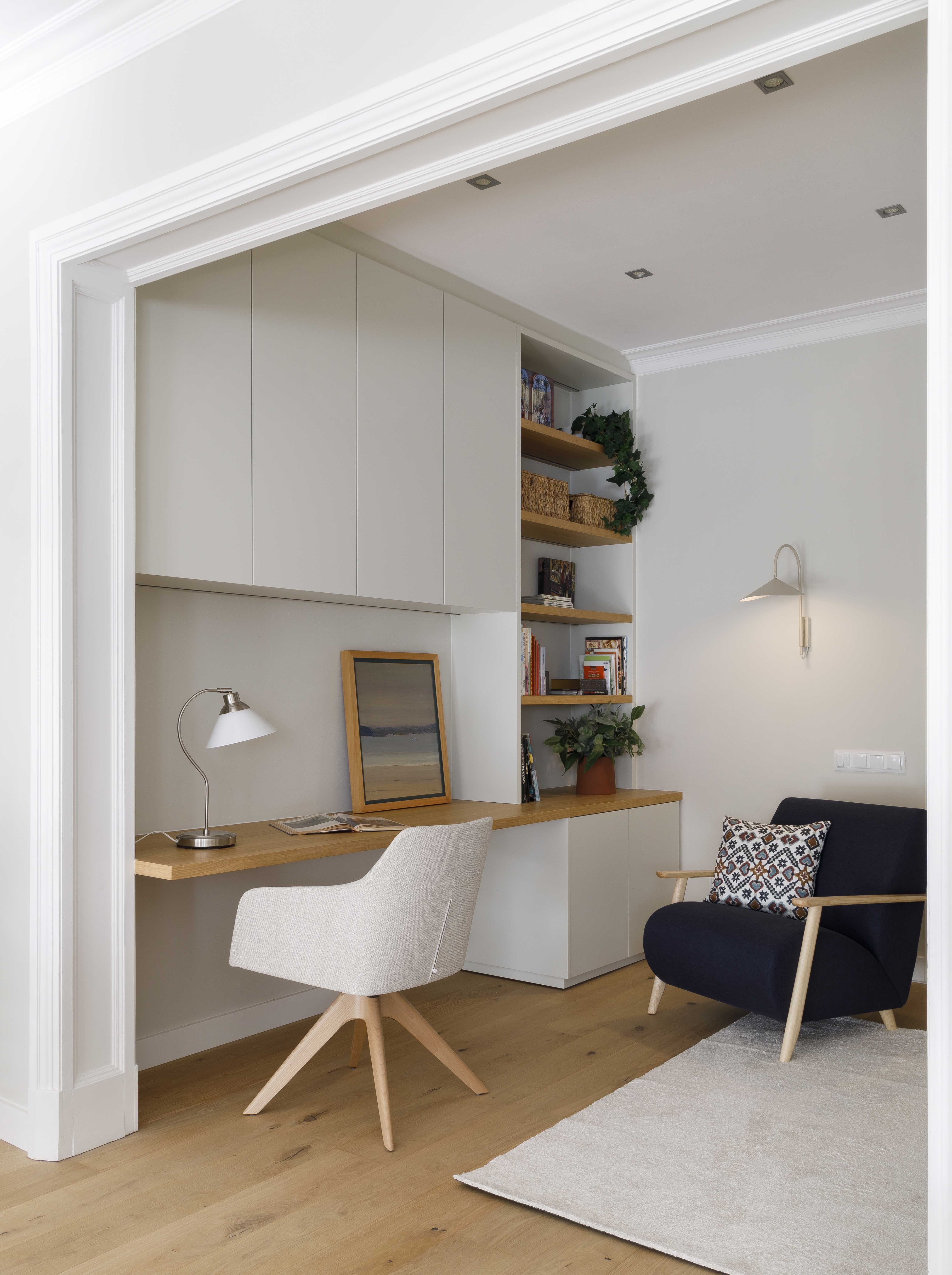 Zona de teletrabajo integrada en el salón con escritorio a medida y almacenaje en una vivienda familiar reformada