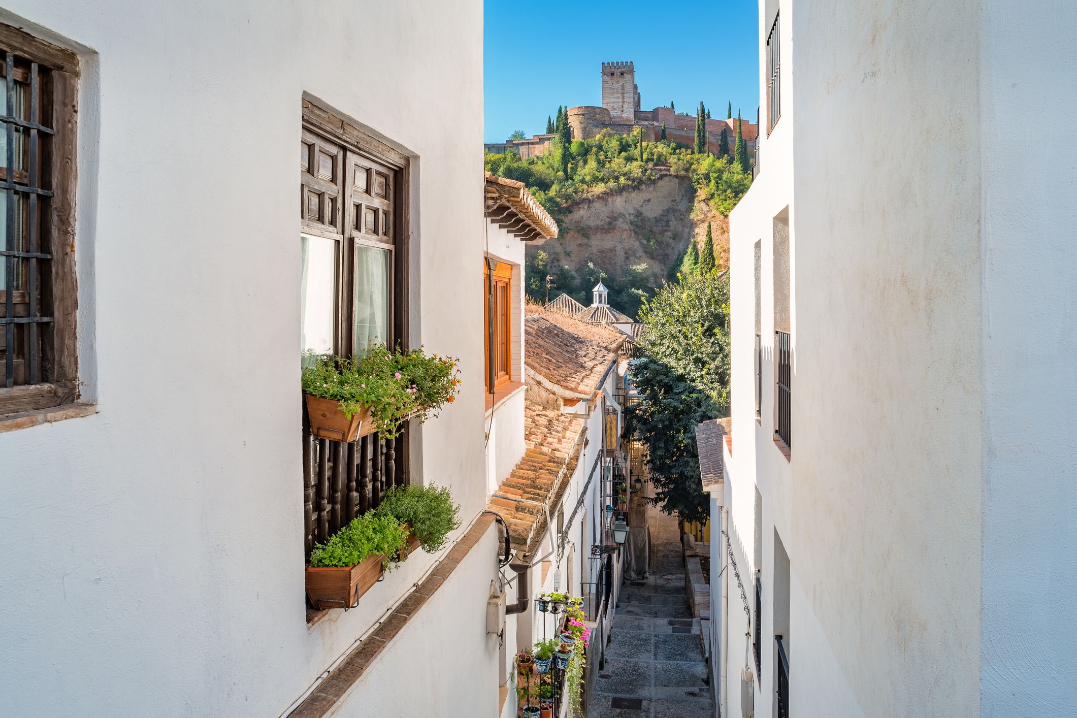 Calle del barrio del Albaicín con vistas a la Alhambra, uno de los mejores barrios para vivir en Granada