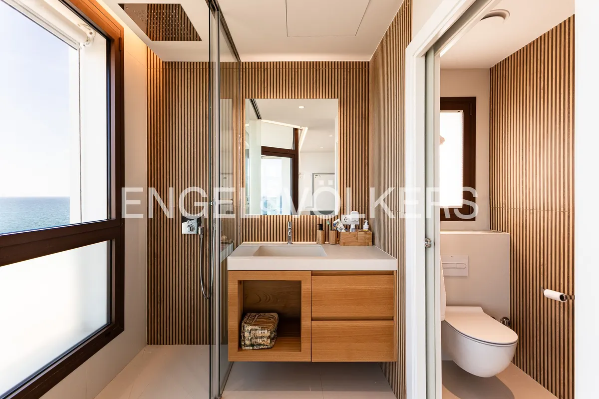 Baño de una casa en Sant Pol de Mar con revestimiento de madera, ducha de obra y diseño contemporáneo.