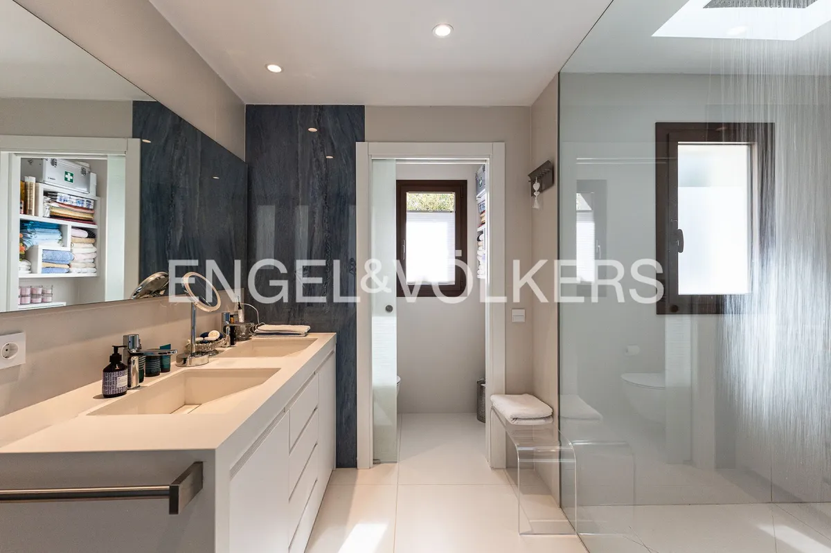 Baño principal de una casa en Sant Pol de Mar con ducha efecto lluvia, doble lavabo y diseño contemporáneo.