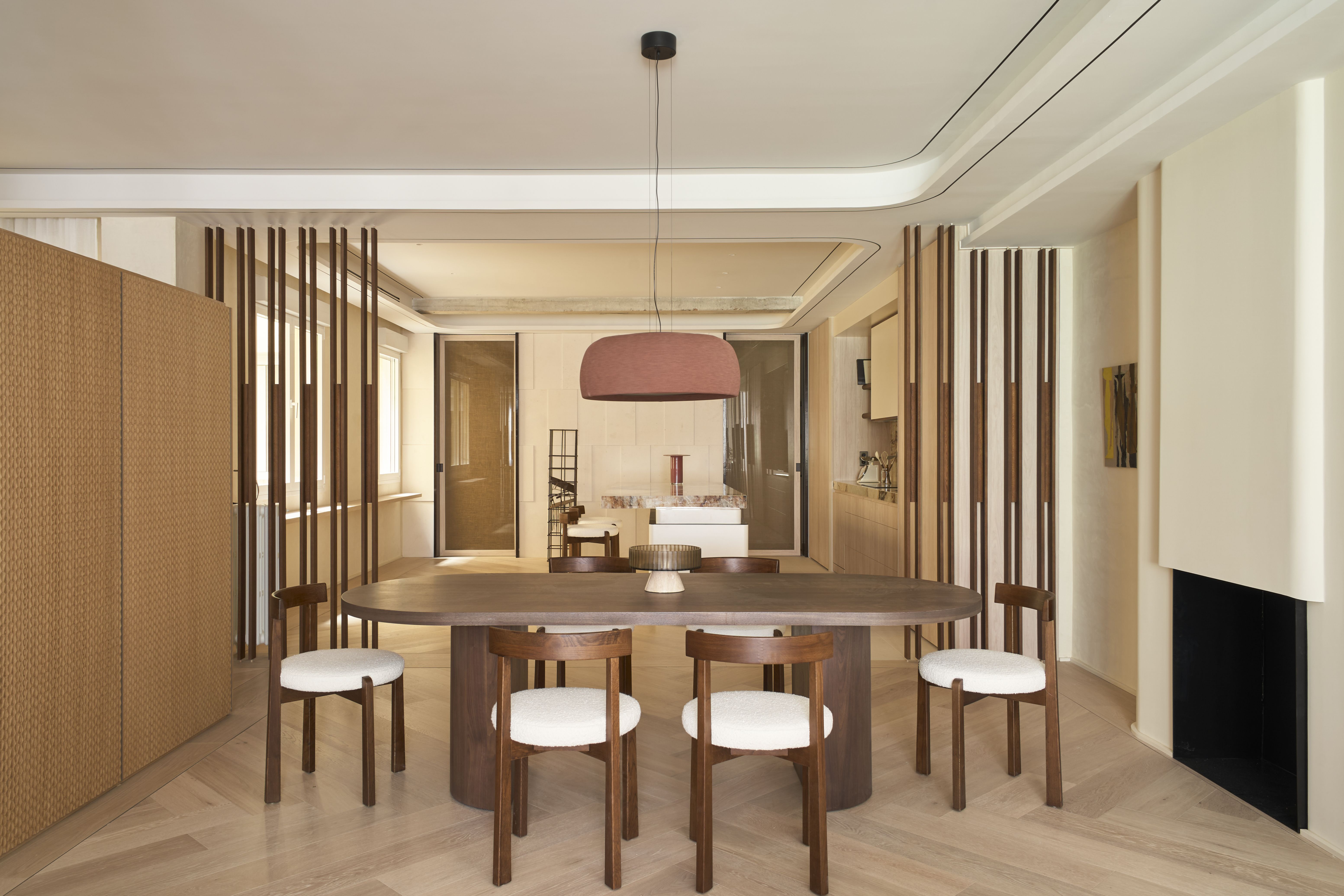 Comedor contemporáneo con mesa ovalada de madera integrado en un espacio abierto.