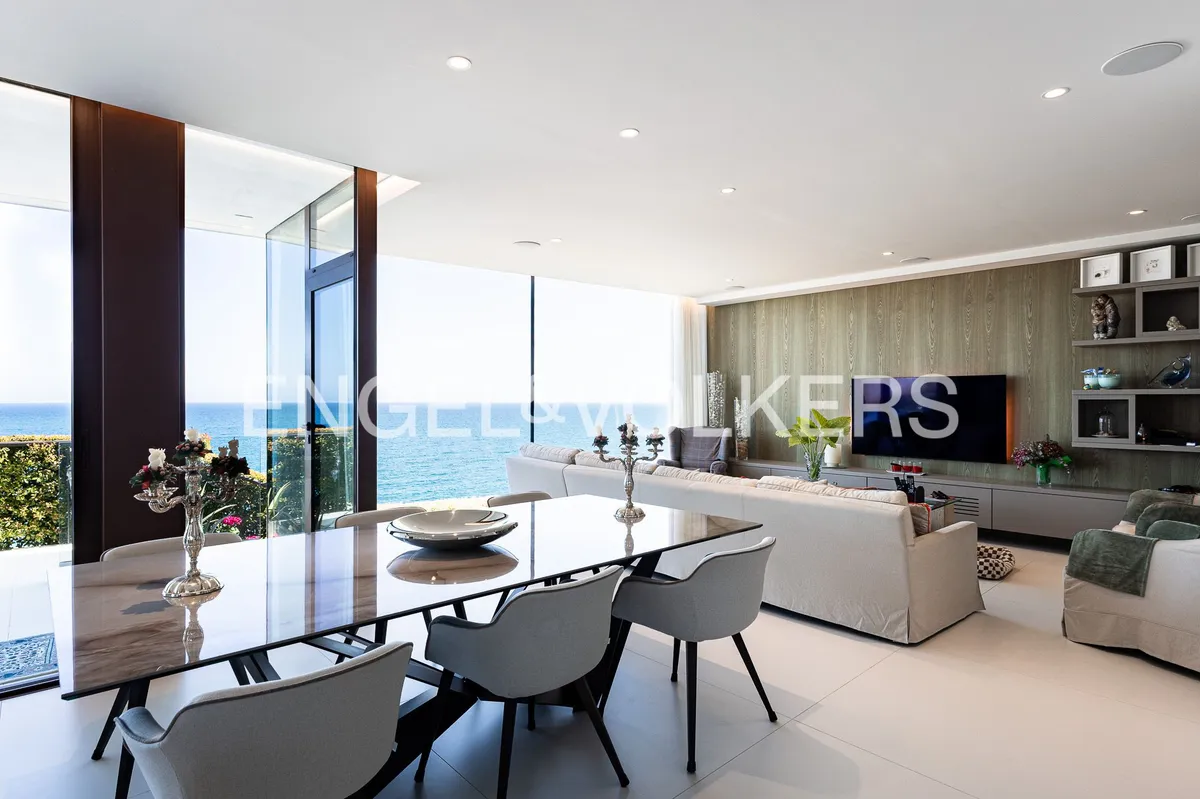 Comedor y salón de una casa en Sant Pol de Mar con grandes ventanales y vistas panorámicas al Mediterráneo.